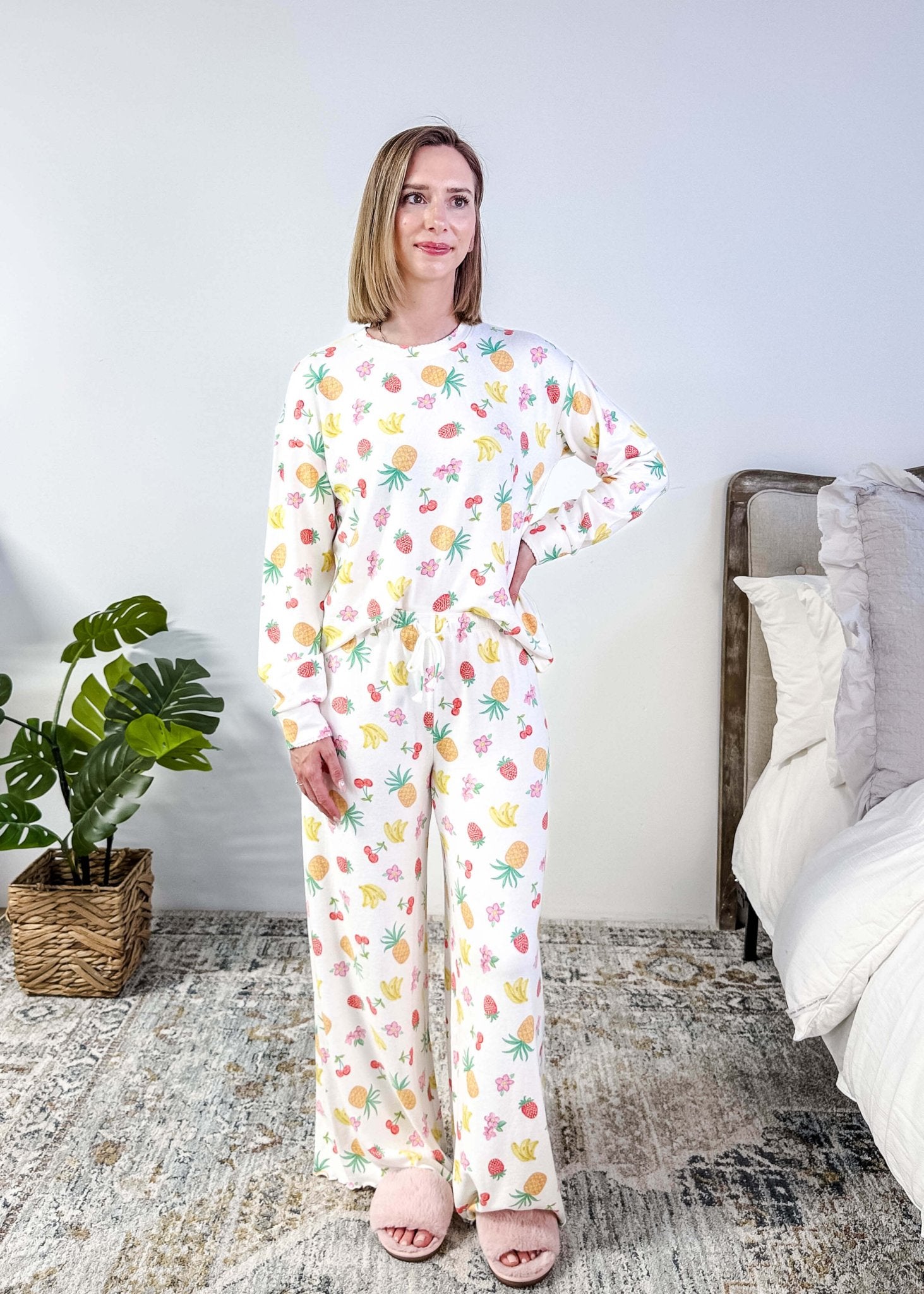 PJ SALVAGE — Viva la Vida Fruit Fiesta Long Sleeve & Pant Set worn on model in a bedroom setting, showing full length of the fruit print pj set with the top tucked in to show the drawstring