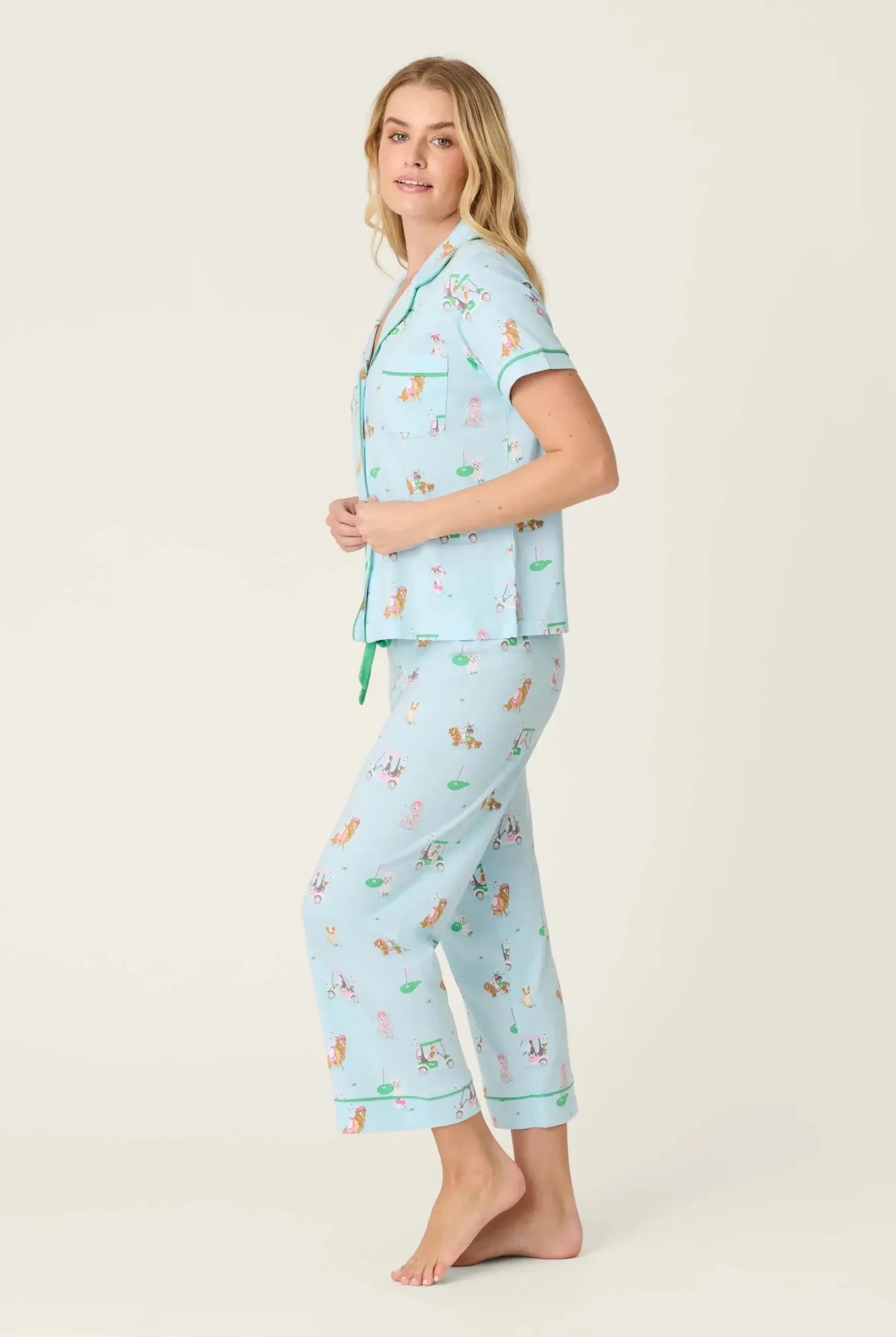 PJ SALVAGE Whimsy Cropped PJ Set in Light Blue Putter Pup print showing dogs golfing. Model stands wearing the set against a light background in a side profile showing the fit