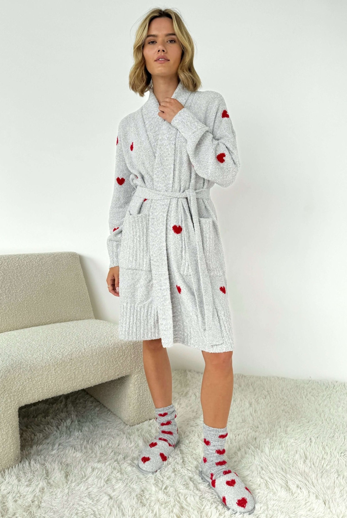 Model wearing the Pomona Fuzzy Yarn Robe Splendid in gray with red hearts, showing length of robe standing