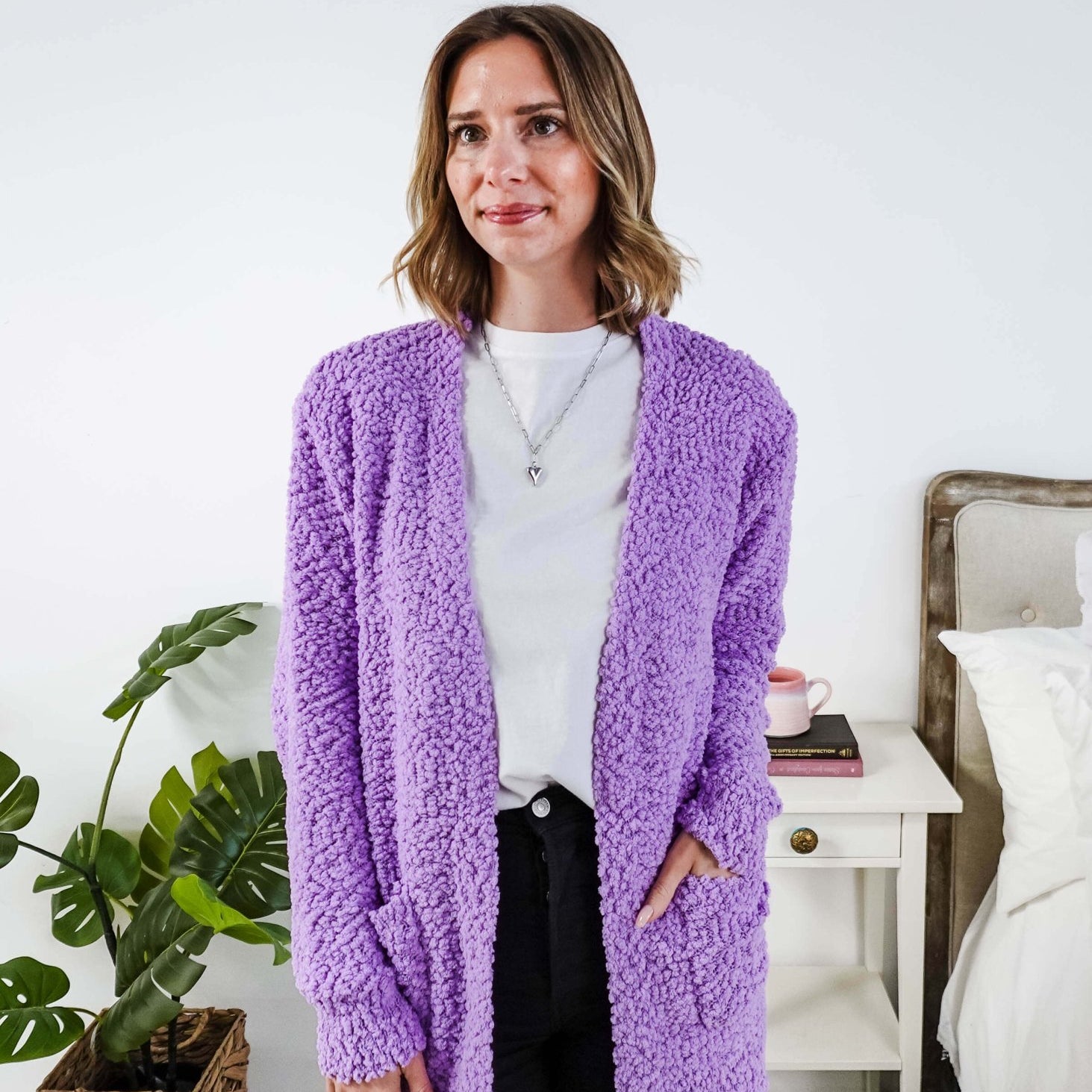 Popcorn Texture Open Summer Cardigan in lilac purple colour shown on model with jeans and white tee shirt, in a bedroom setting.