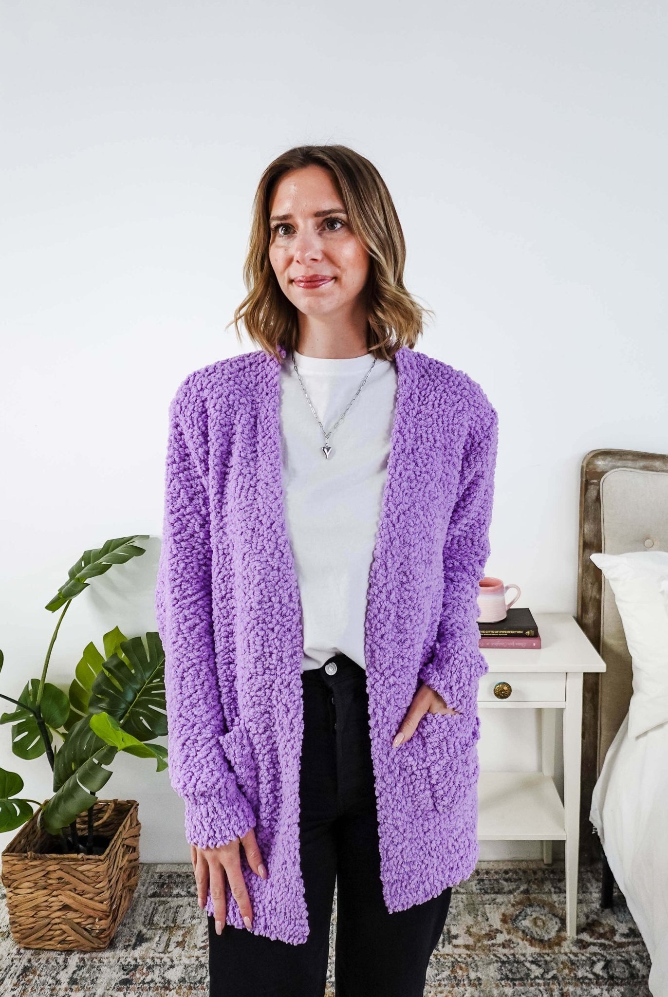 Popcorn Texture Open Summer Cardigan in lilac purple colour shown on model with jeans and white tee shirt, in a bedroom setting.