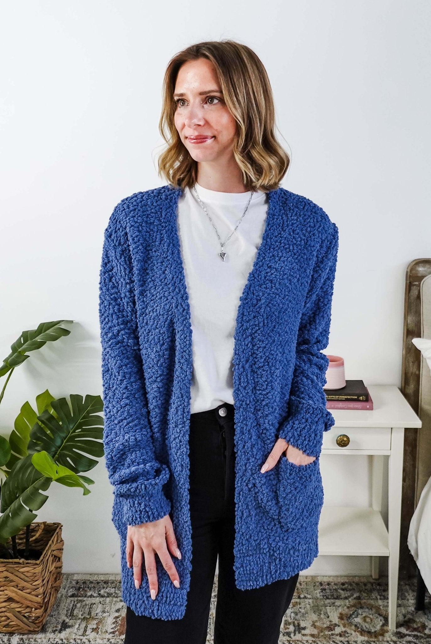 Popcorn Texture Open Summer Cardigan in blue, shown on model in a bedroom setting with hand in pocket