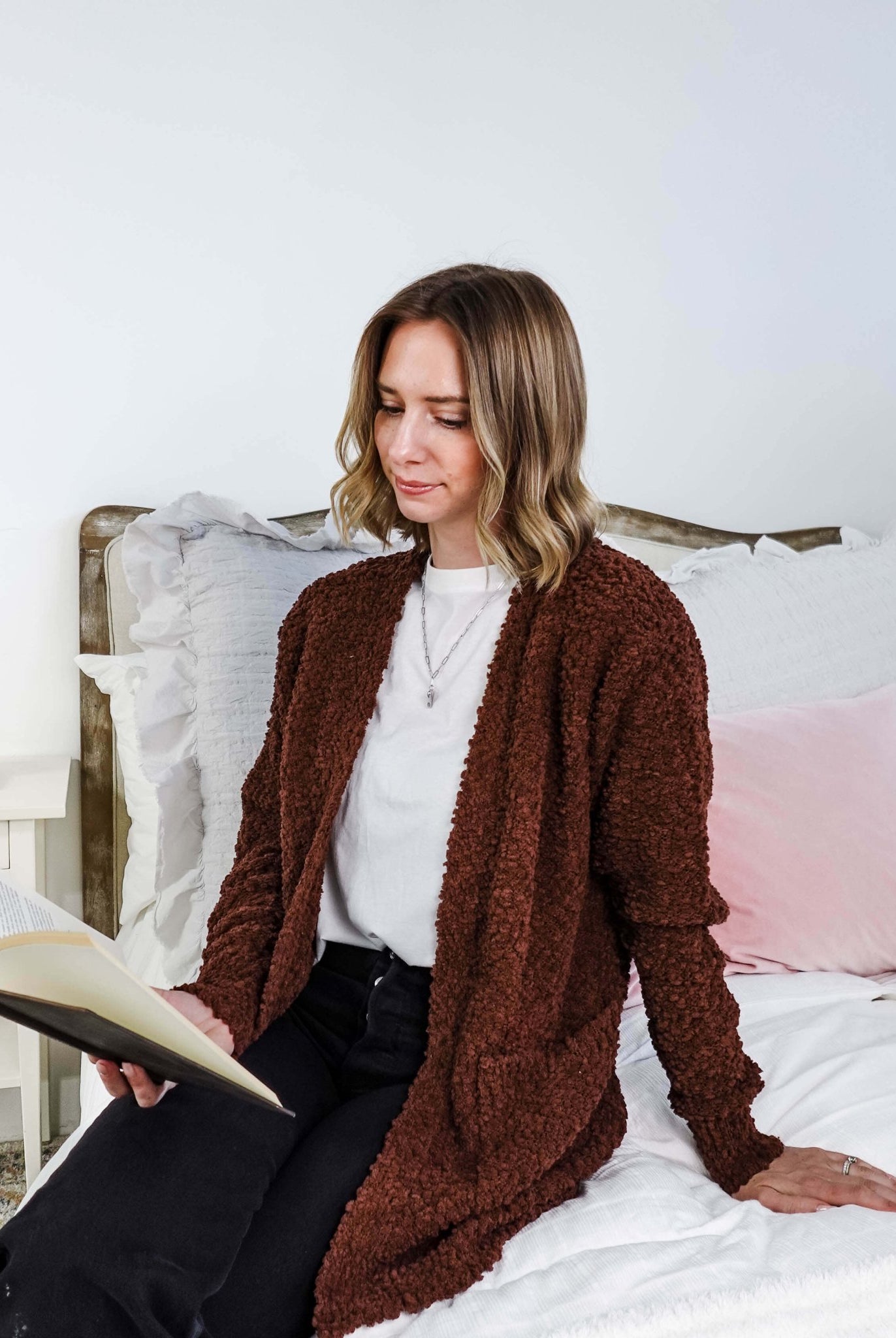 Woman reading a book on a bed wearing a brown cardigan, Popcorn Texture Open Summer Cardigan
