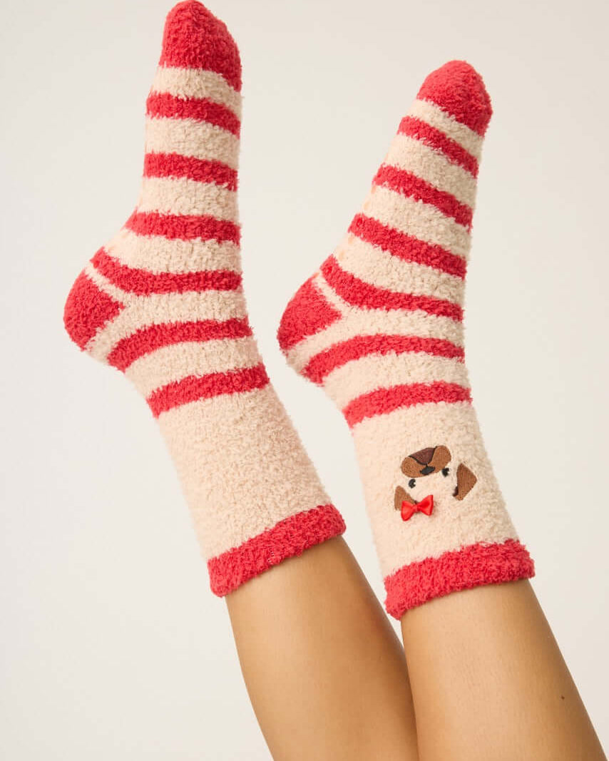 Pair of PJ Salvage Red & Tan Stripe Fuzzy Cozy Socks with the adorable pug embroidered with a bow detail. Anti-skid grippers visible on the bottom.