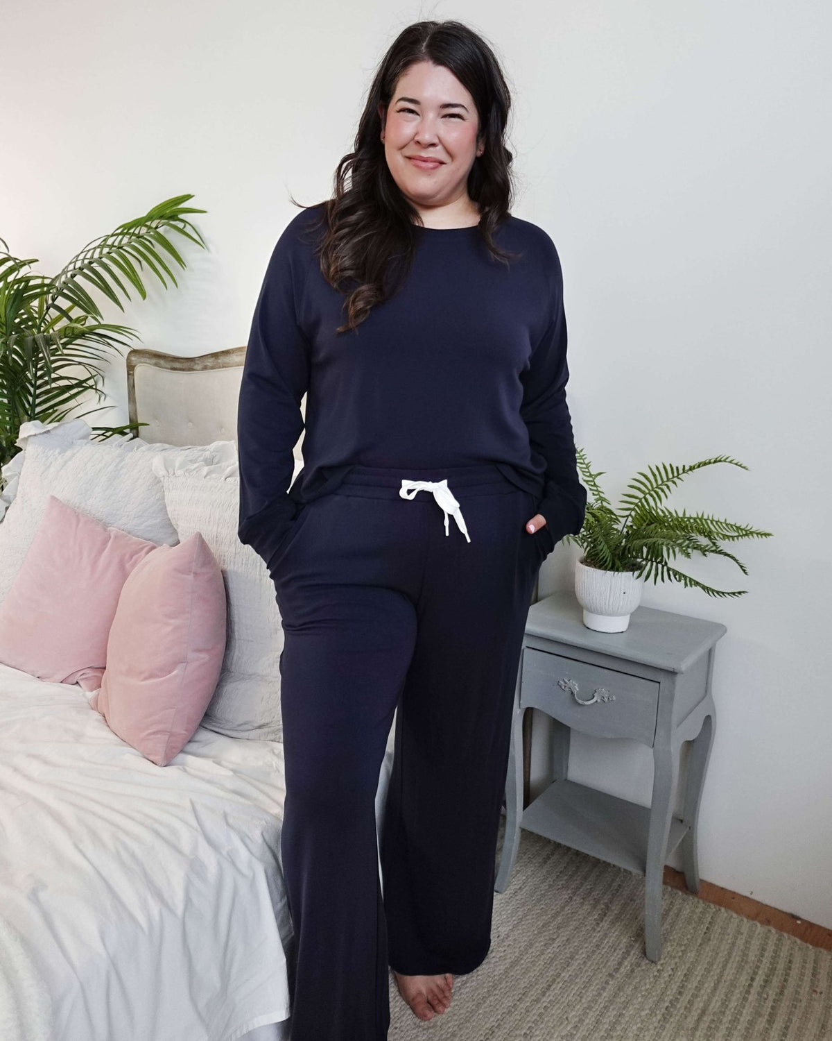 Model wearing Long Sleeve Raw Edge Straight Pant Lounge Set in navy color, posing in a cozy bedroom setting.