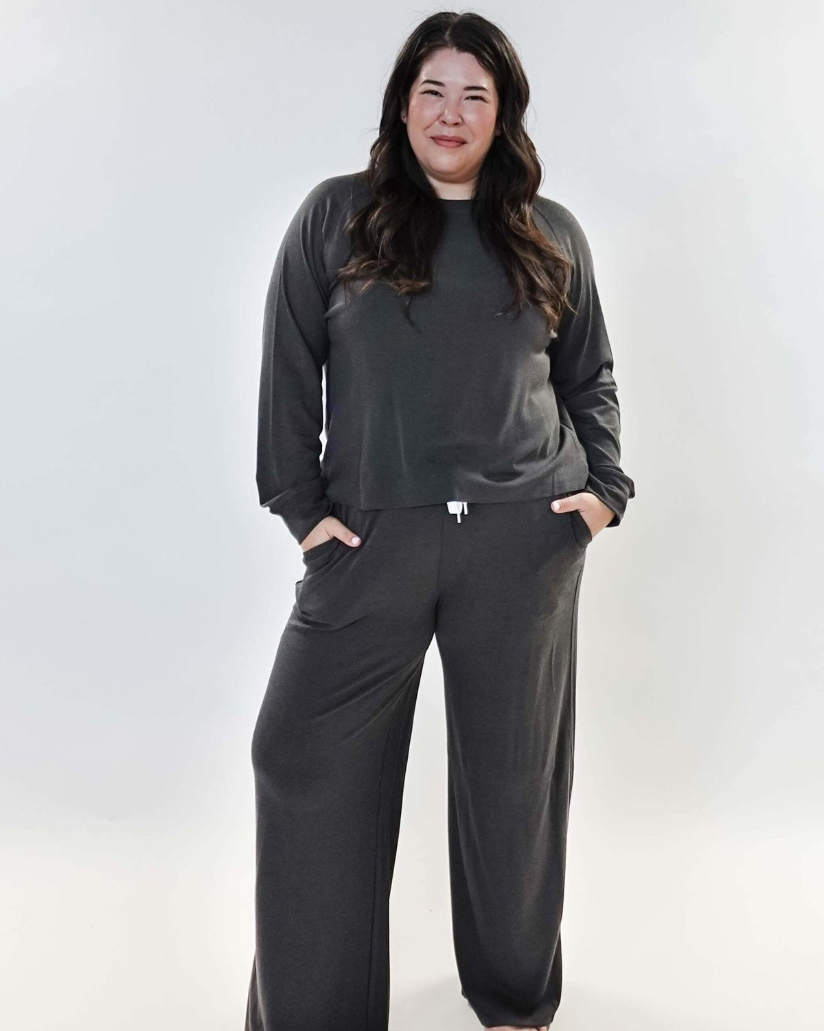 Model wearing the Long Sleeve Raw Edge Straight Pant Lounge Set in gray, featuring a relaxed fit and pockets.