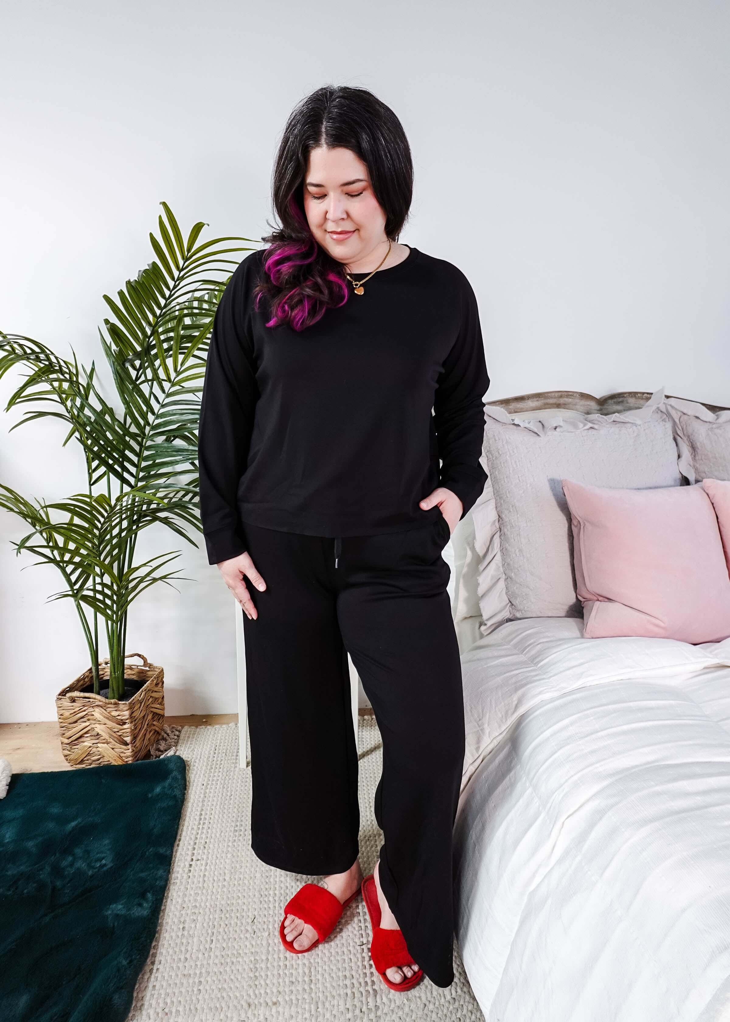 Model wearing Black Long Sleeve Raw Edge Straight Pant Cloud Lounge Set with red slippers in a cozy bedroom setting.