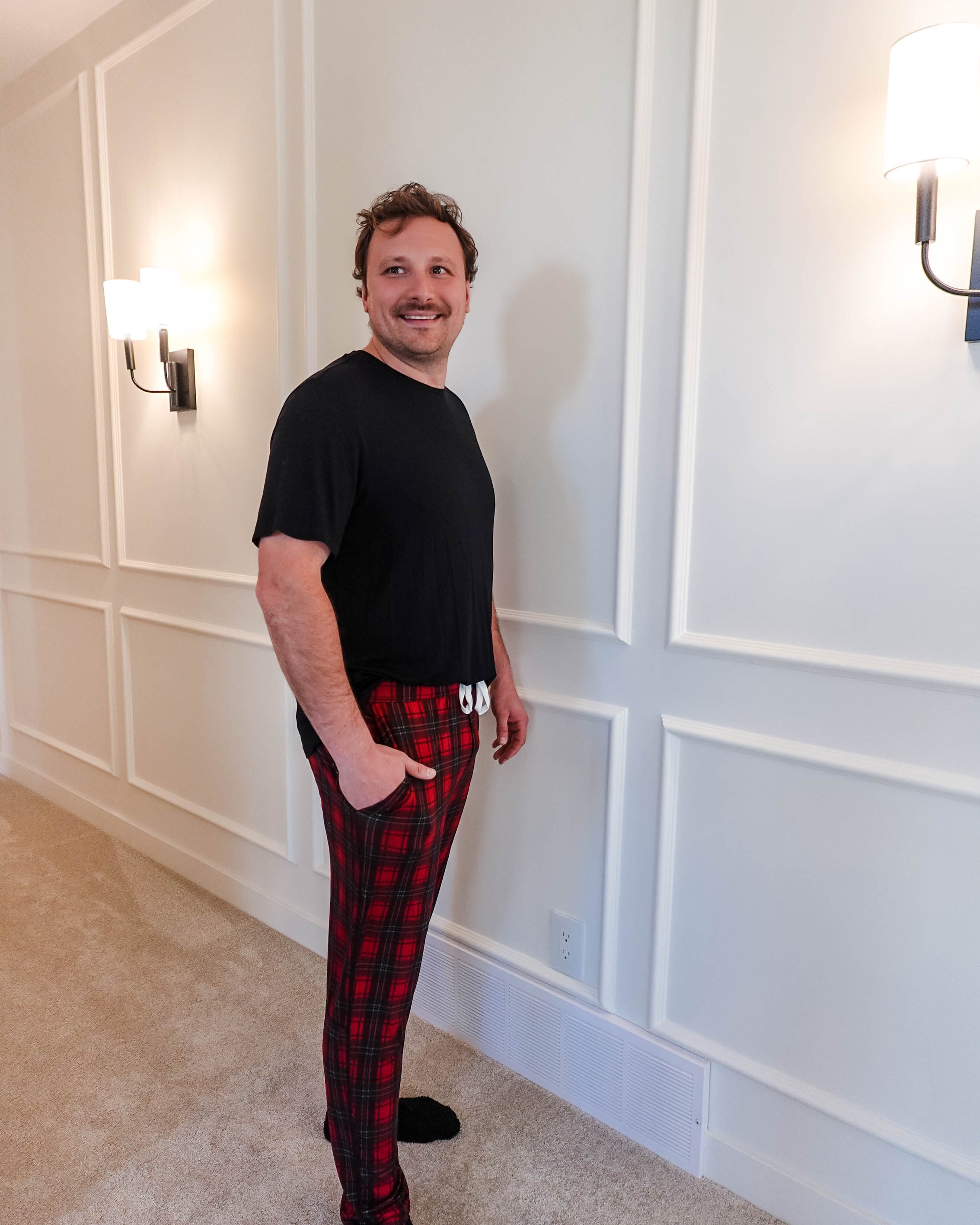 unisex joggers for men and women holiday red plaid print in soft bamboo fabric. Man wearing with classic black tee - view from side