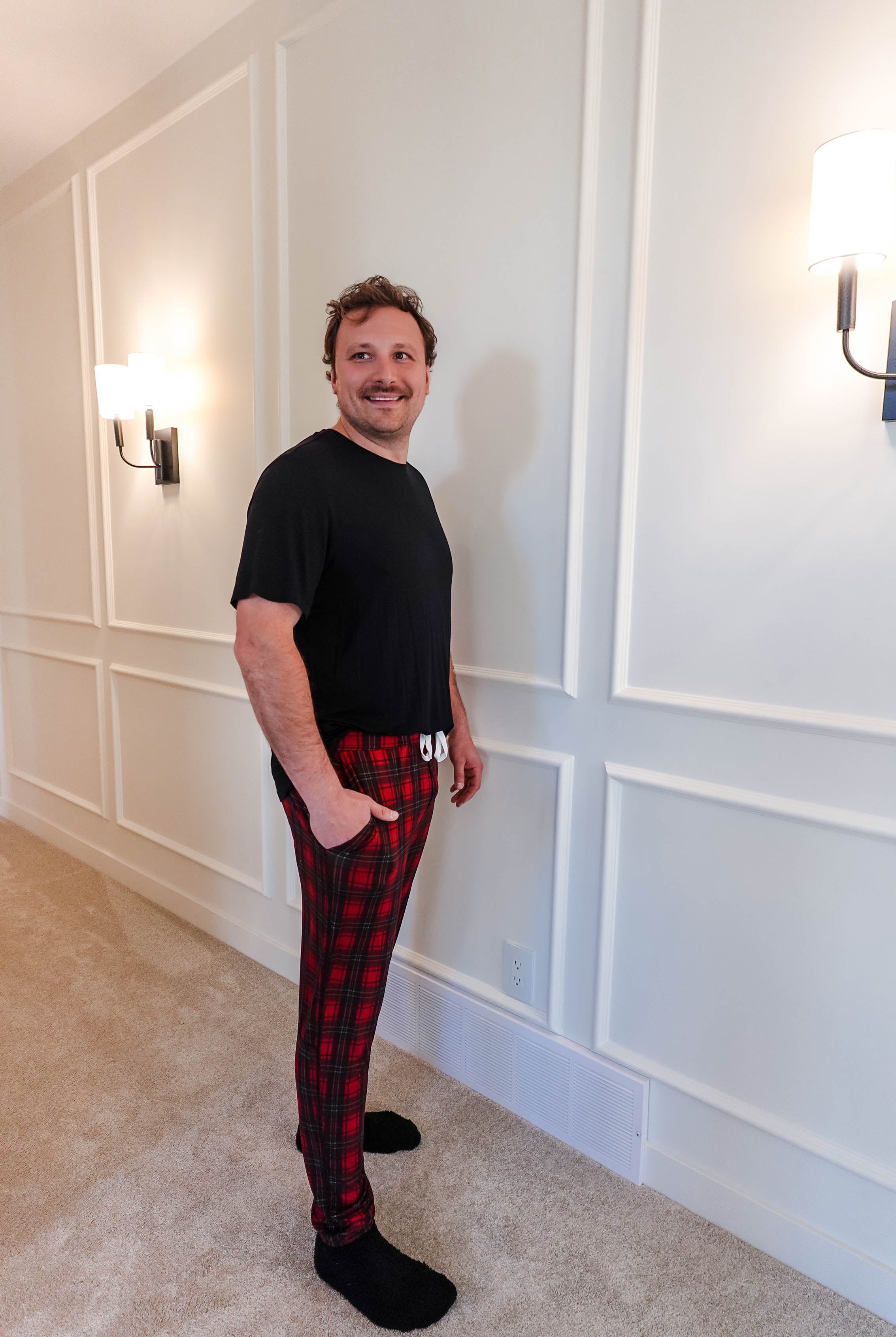 unisex joggers for men and women holiday red plaid print in soft bamboo fabric. Man wearing with classic black tee - view from side