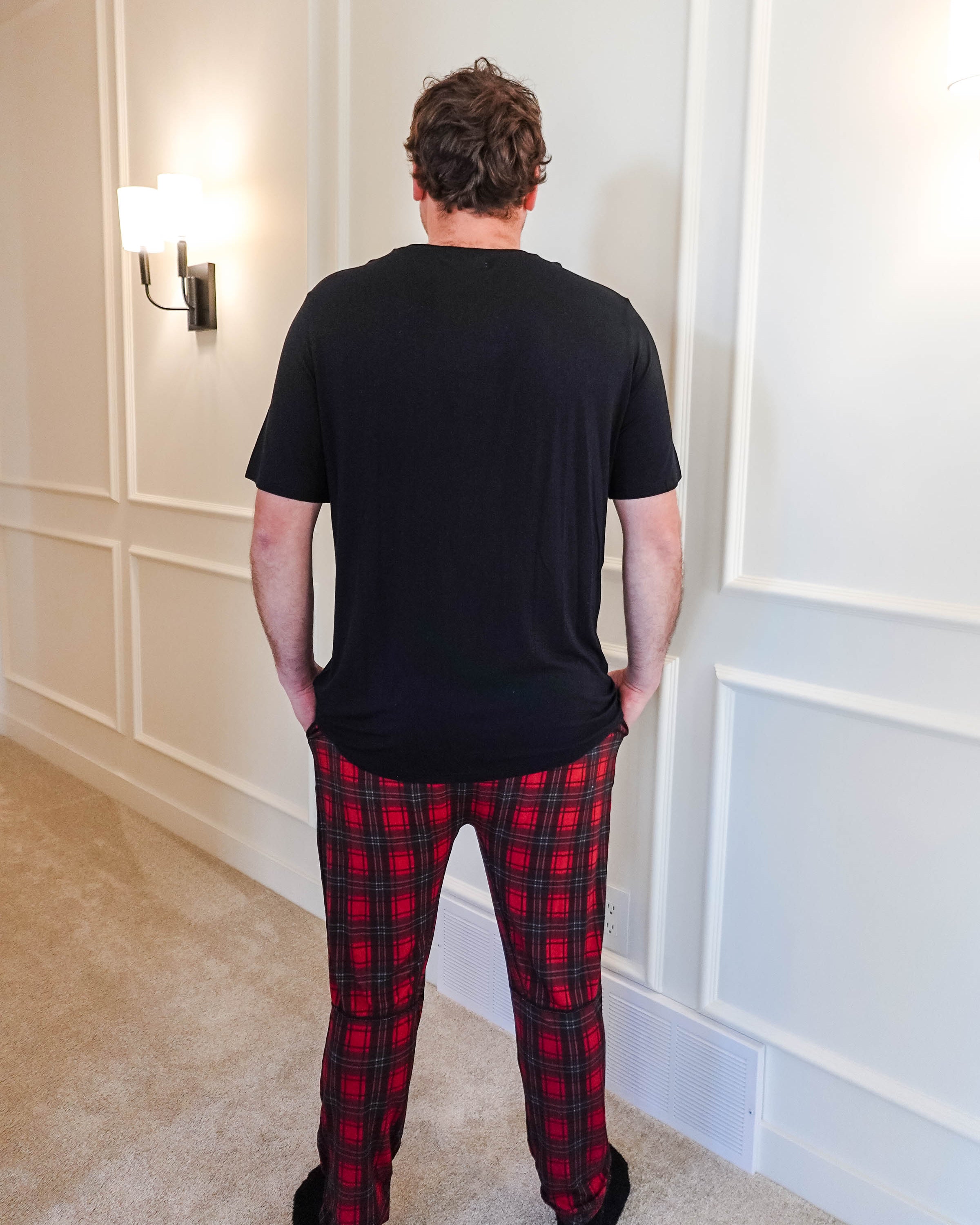 unisex joggers for men and women holiday red plaid print in soft bamboo fabric. Man wearing with classic black tee - view from back