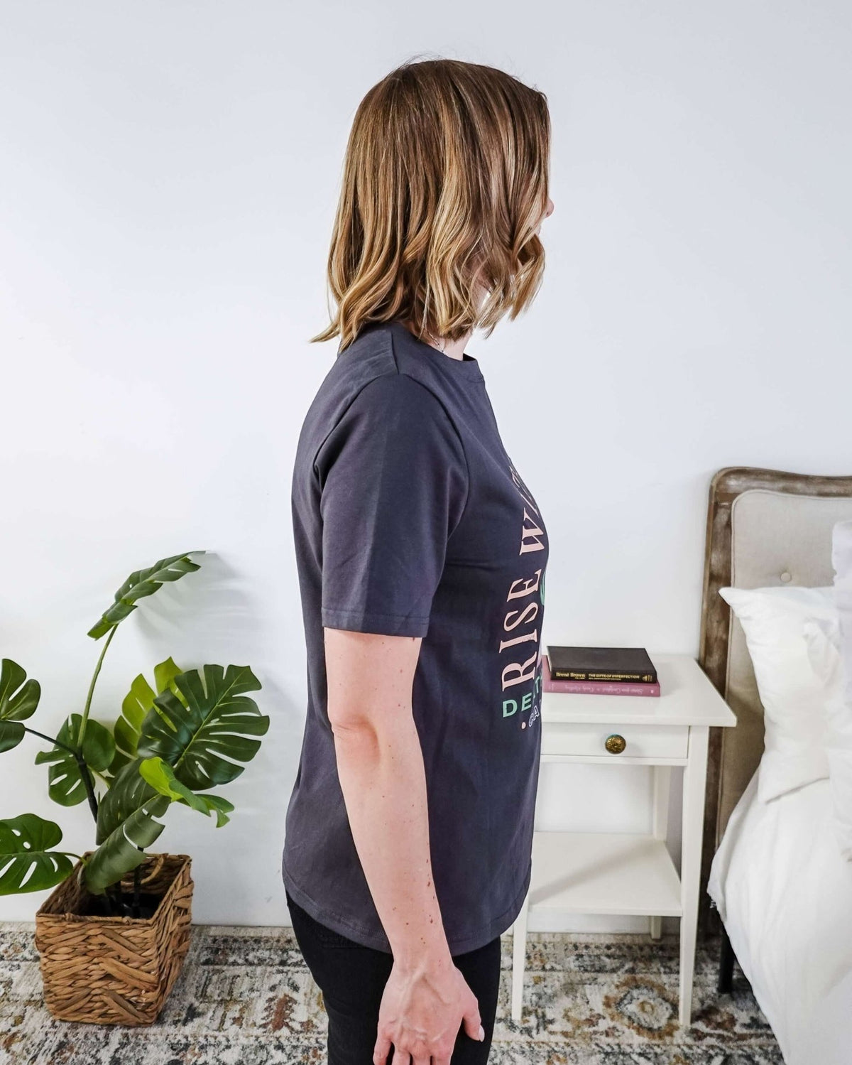 women wearing a dark grey graphic t-shirt with the saying rise with the sun death valley california