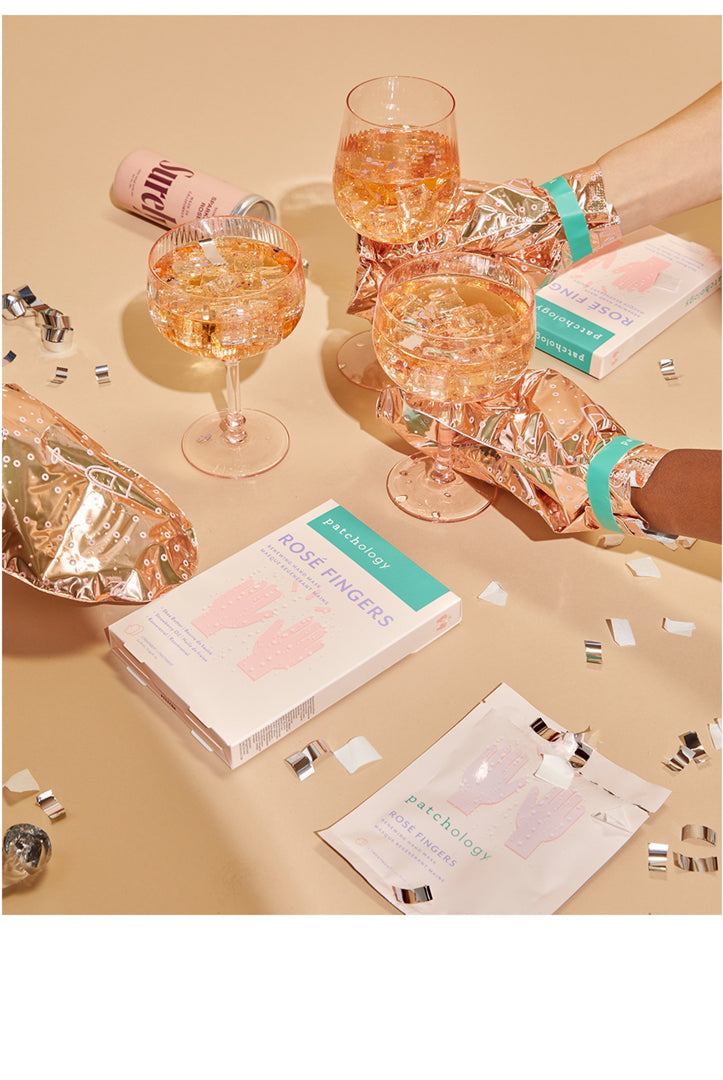 Glasses of rose wine with packaging on a beige surface, Patchology Rosé Fingers renewing hand mask rose gold gloves shea butter