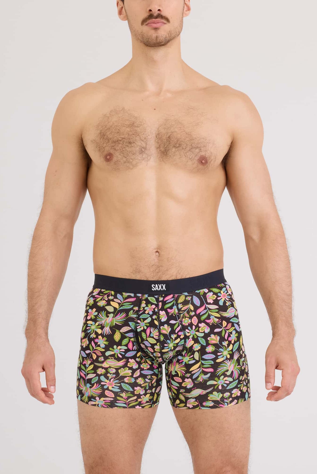 Vibe Xtra Soft Comfort Boxer Brief worn by a man, featuring a colorful floral print design from SAXX.