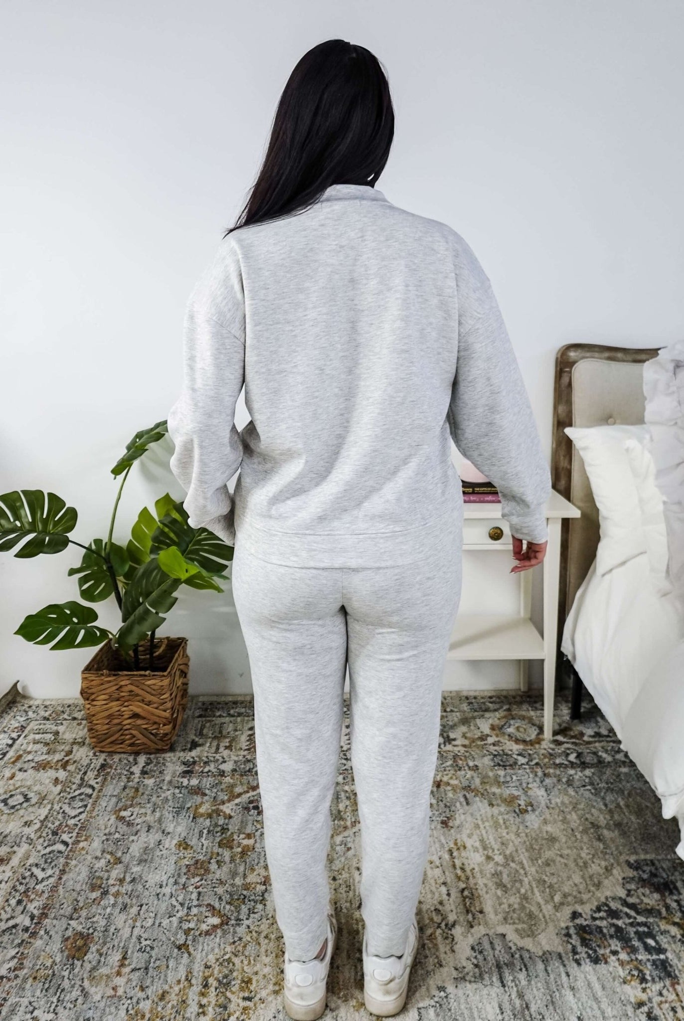 Person wearing a gray loungewear set in a bedroom setting.