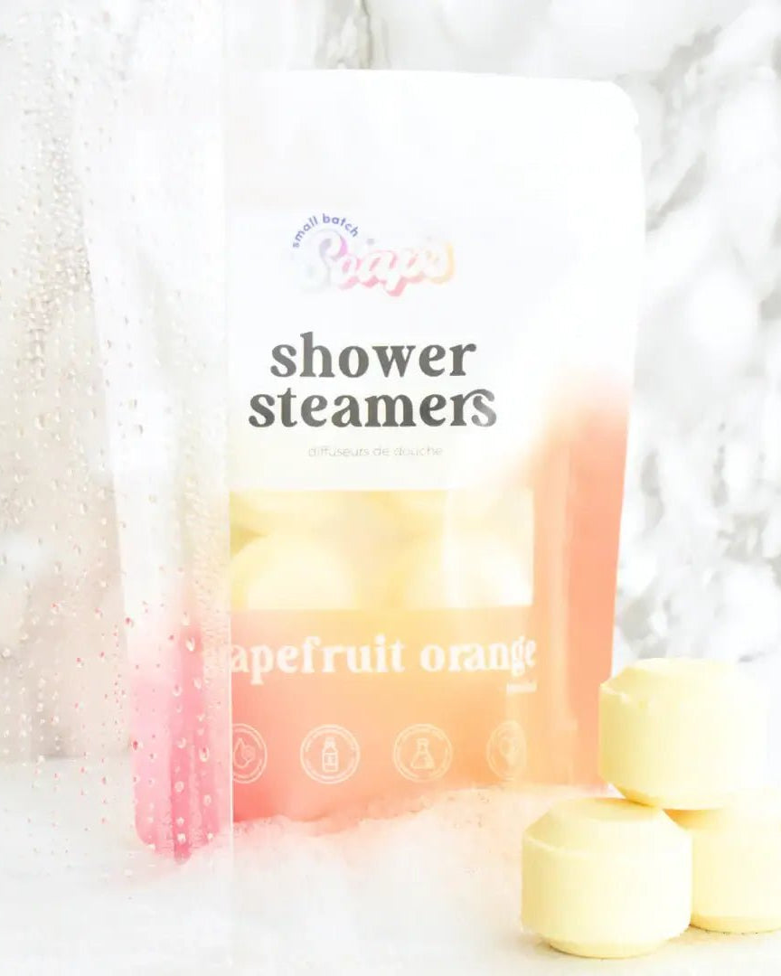Shower Steamer 6pk Grapefruit Orange packaging with shower steamers in a relaxing setting.