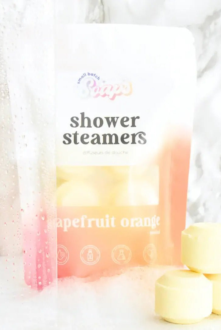 Shower Steamer 6pk Grapefruit Orange packaging with shower steamers in a relaxing setting.