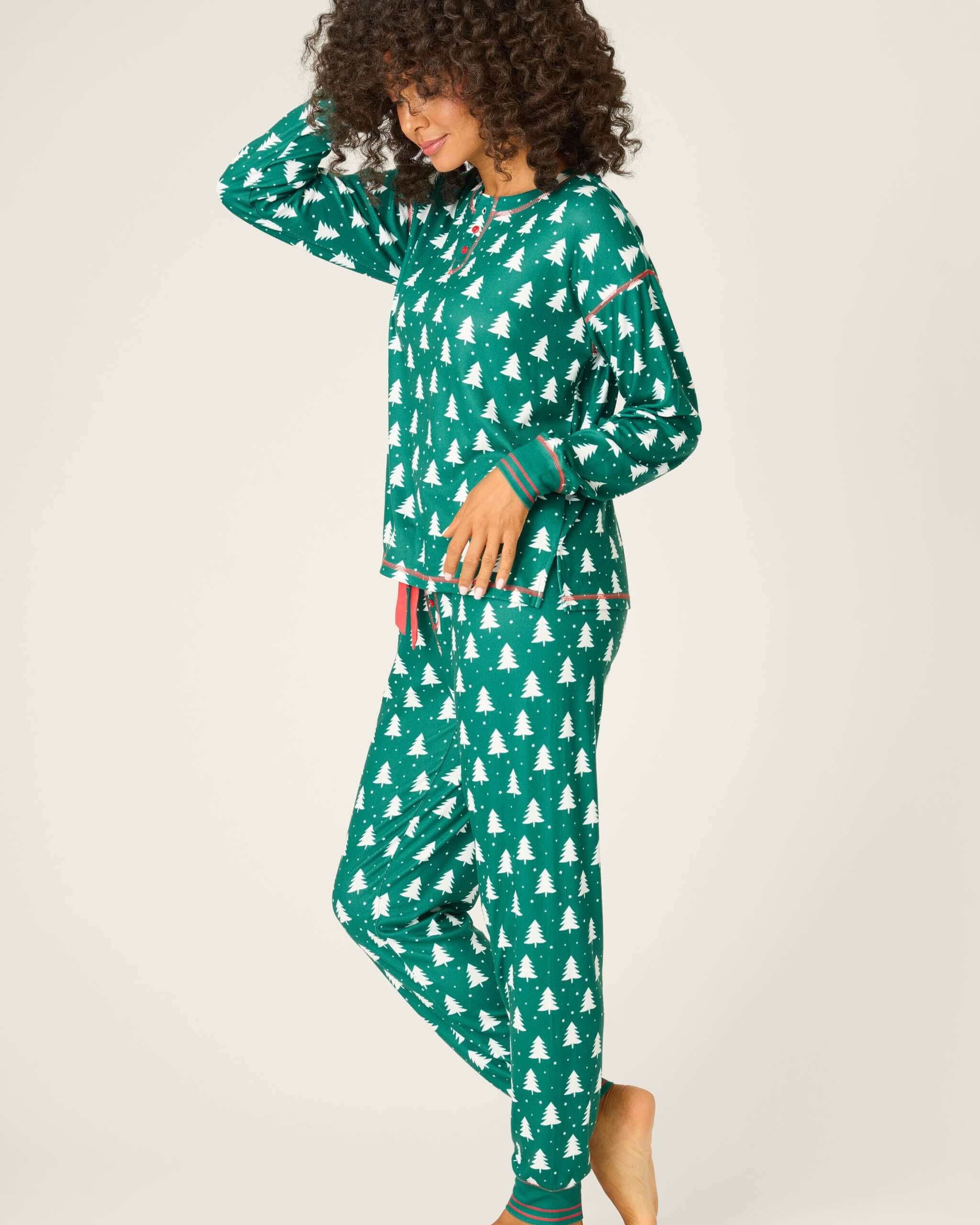 Model wearing Silent Night Pointelle PJ Set in forest green with festive pattern, smiling and looking cozy.