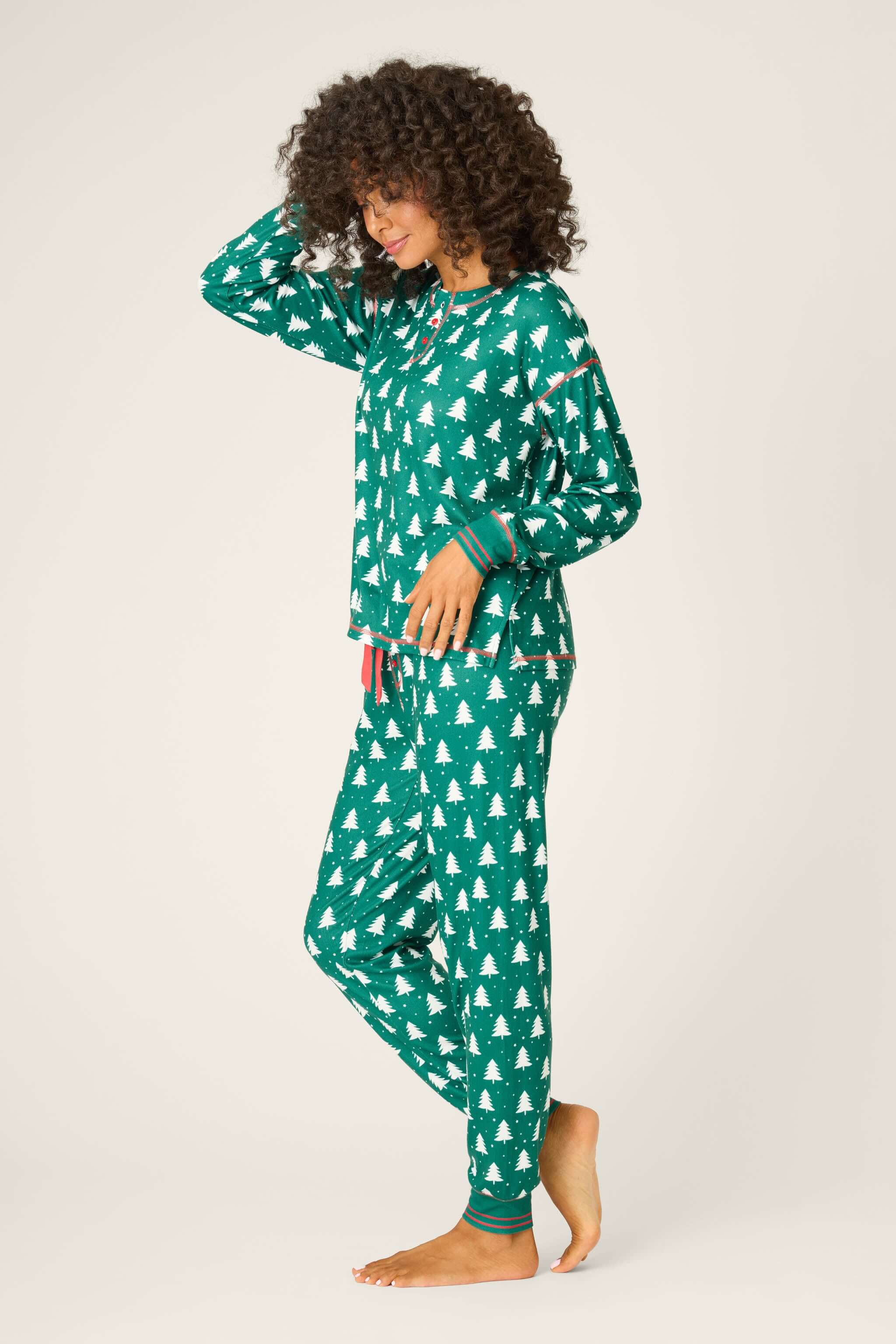 Model wearing Silent Night Pointelle PJ Set in forest green with festive pattern, smiling and looking cozy.