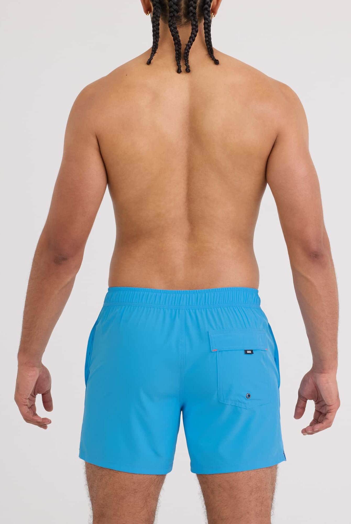 Back view of a man wearing Oh Buoy 2N1 Volley Swim Short in vibrant blue color.