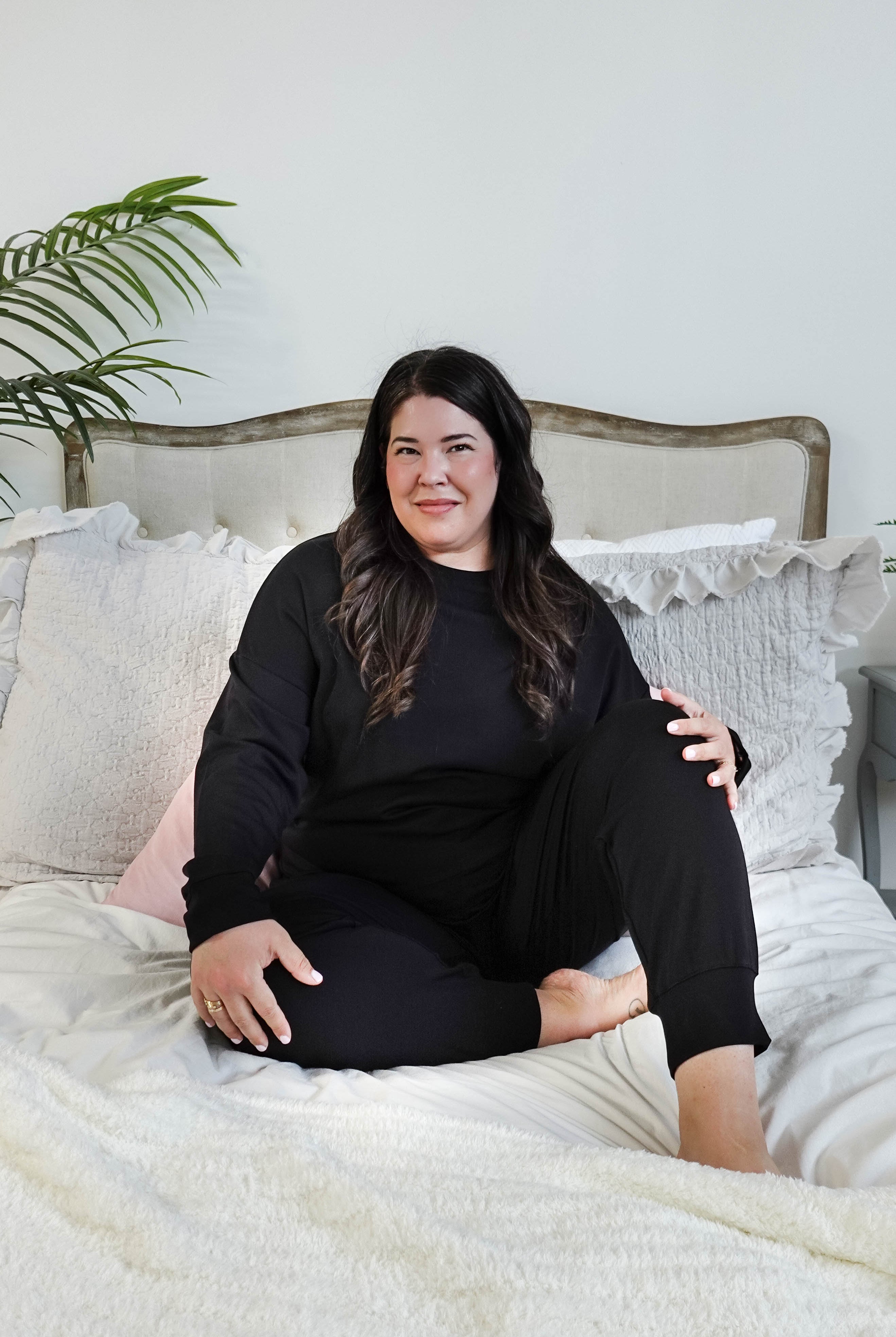 plus size woman sitting wearing black lounge set with top and jogger in bamboo blend