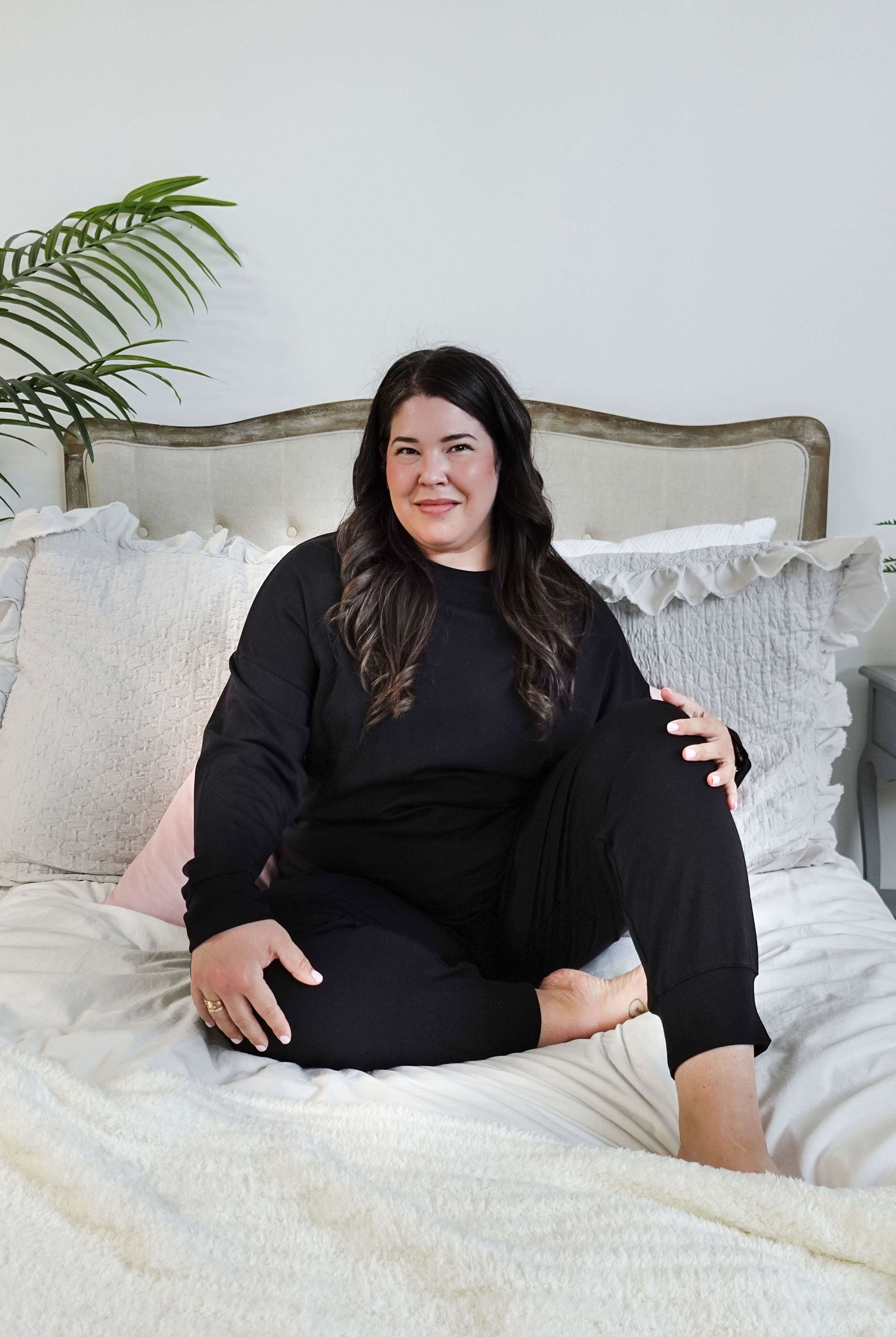 plus size woman sitting wearing black lounge set with top and jogger in bamboo blend