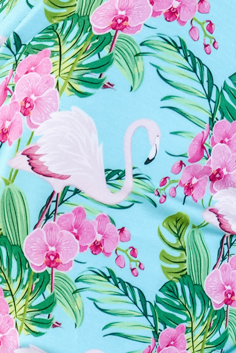 Tropic Like its Hot Print showing close up of fabric, texture and tropical flamingo and floral print on a light blue background