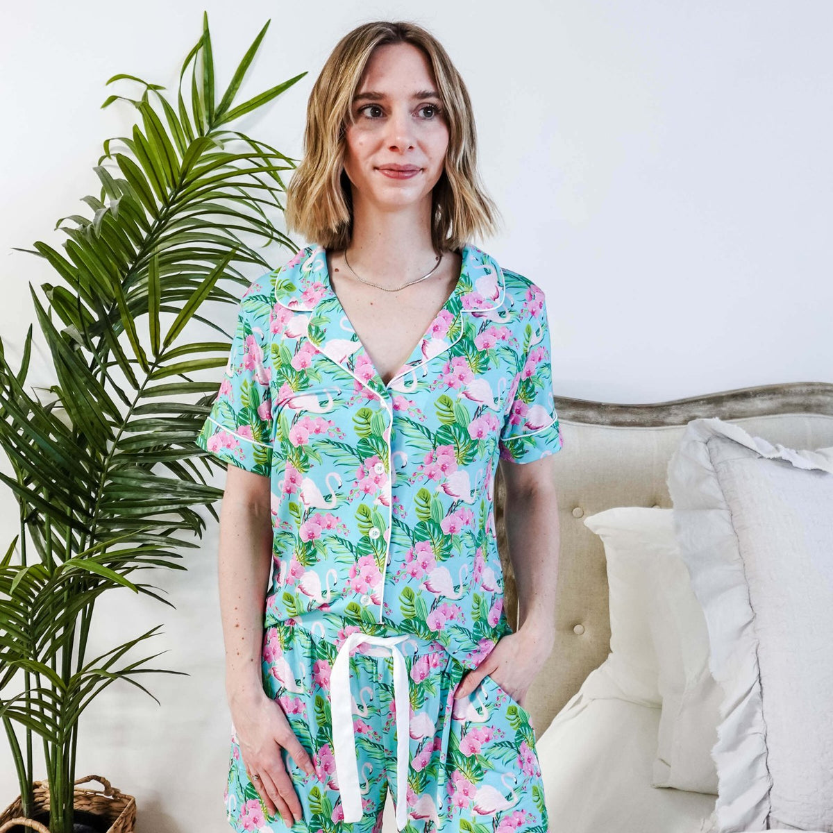 Tropic Like It's Hot Bamboo Short Sleeve Pajama Set worn by a model, featuring pink flamingos and tropical orchids.