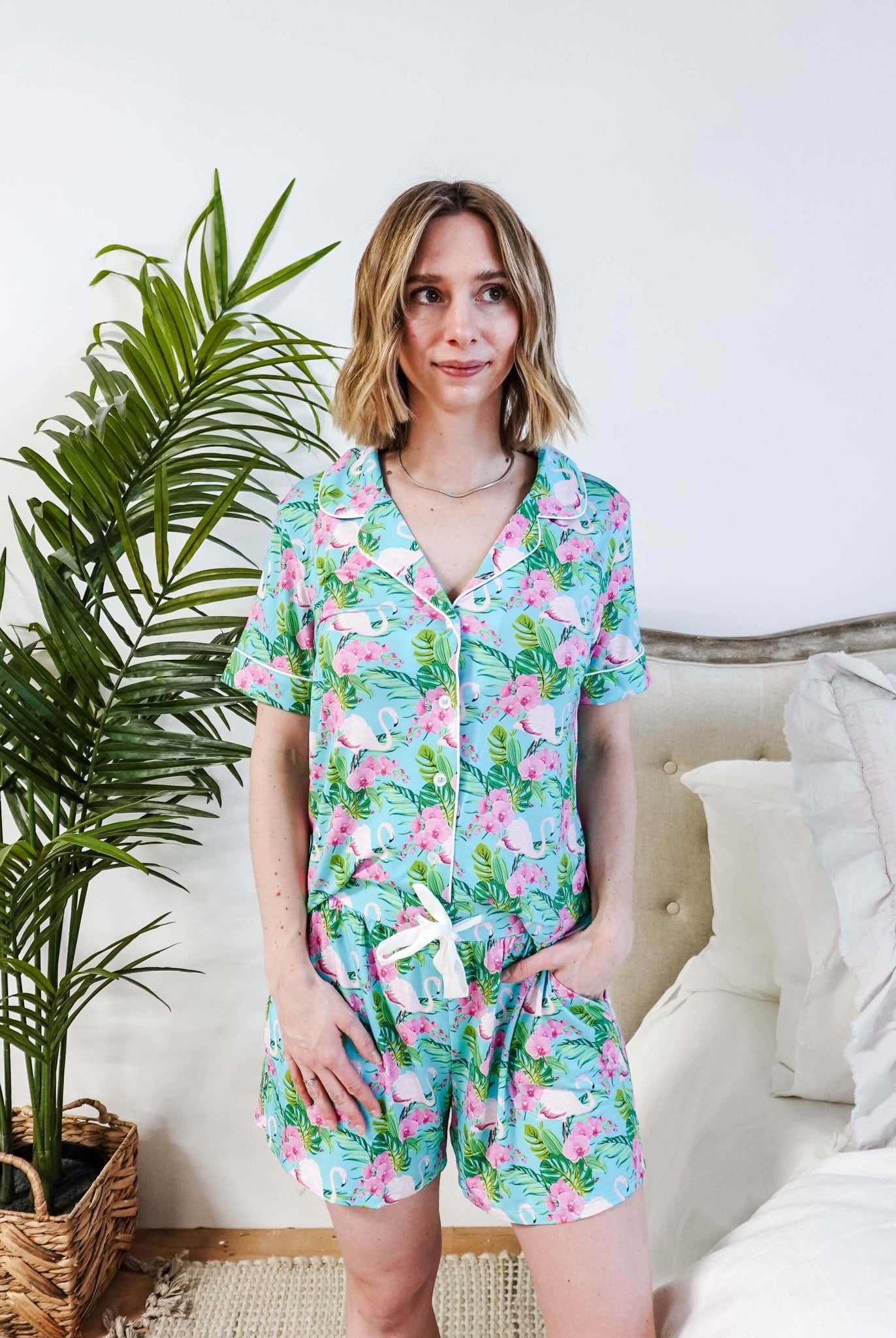 Model wearing Tropic Like It's Hot Bamboo Short Sleeve Pajama Set with pink flamingo and tropical orchid print.