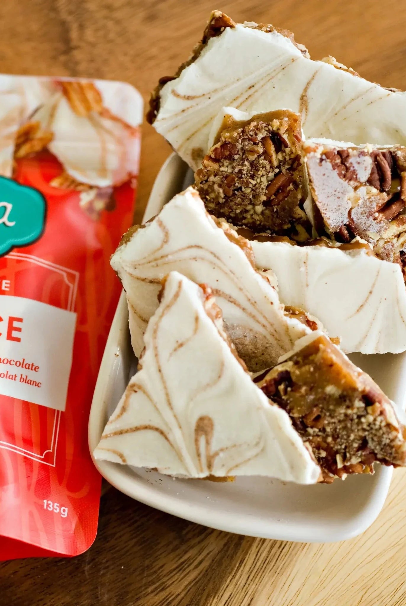 Utoffeea Canada Handcrafted Toffee with pumpkin spice flavor in a bowl next to its packaging.