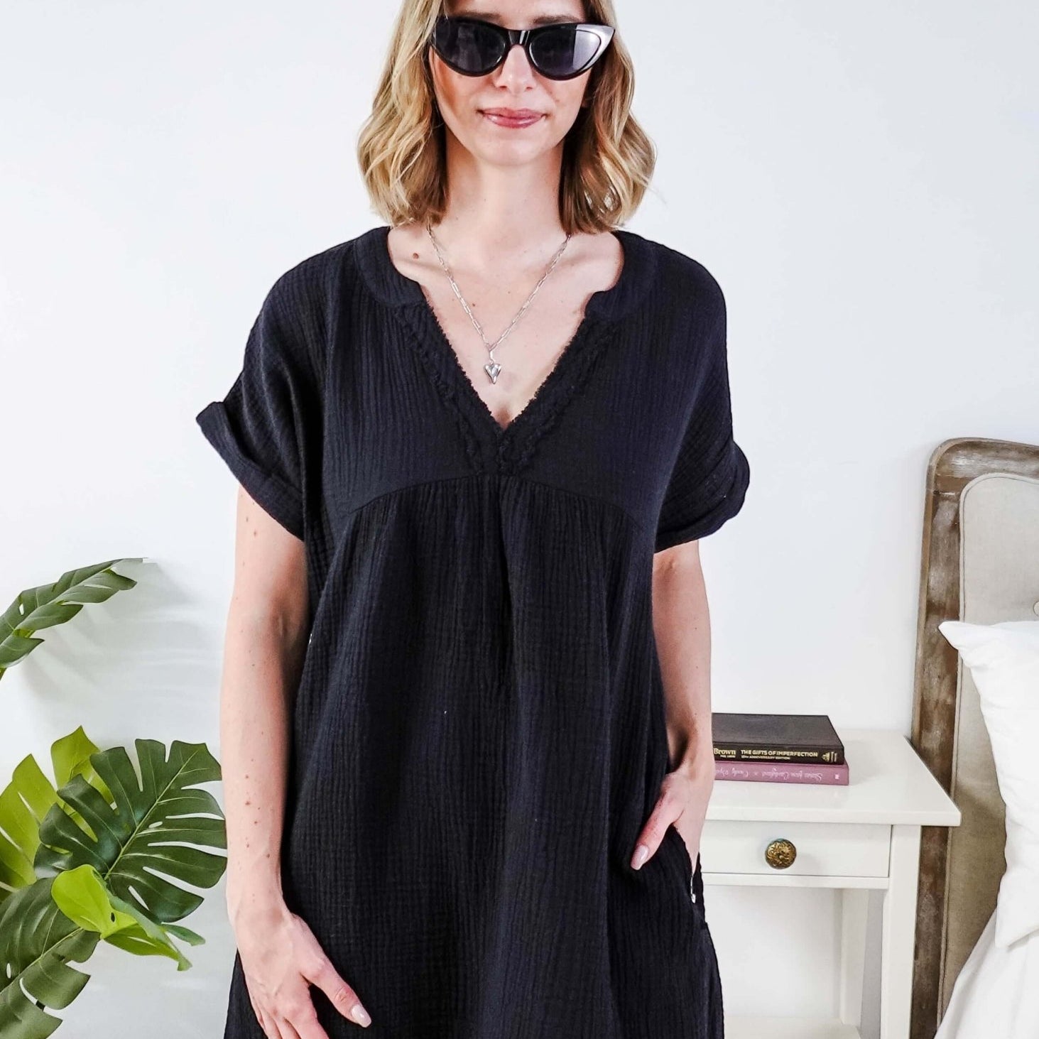 Woman wearing a black dress and sunglasses indoors with a plant and furniture in the background - Scarlett Ellie V-Neck Gauze Dress | Lightweight Summer Dress | Cloud Nine Pajamas