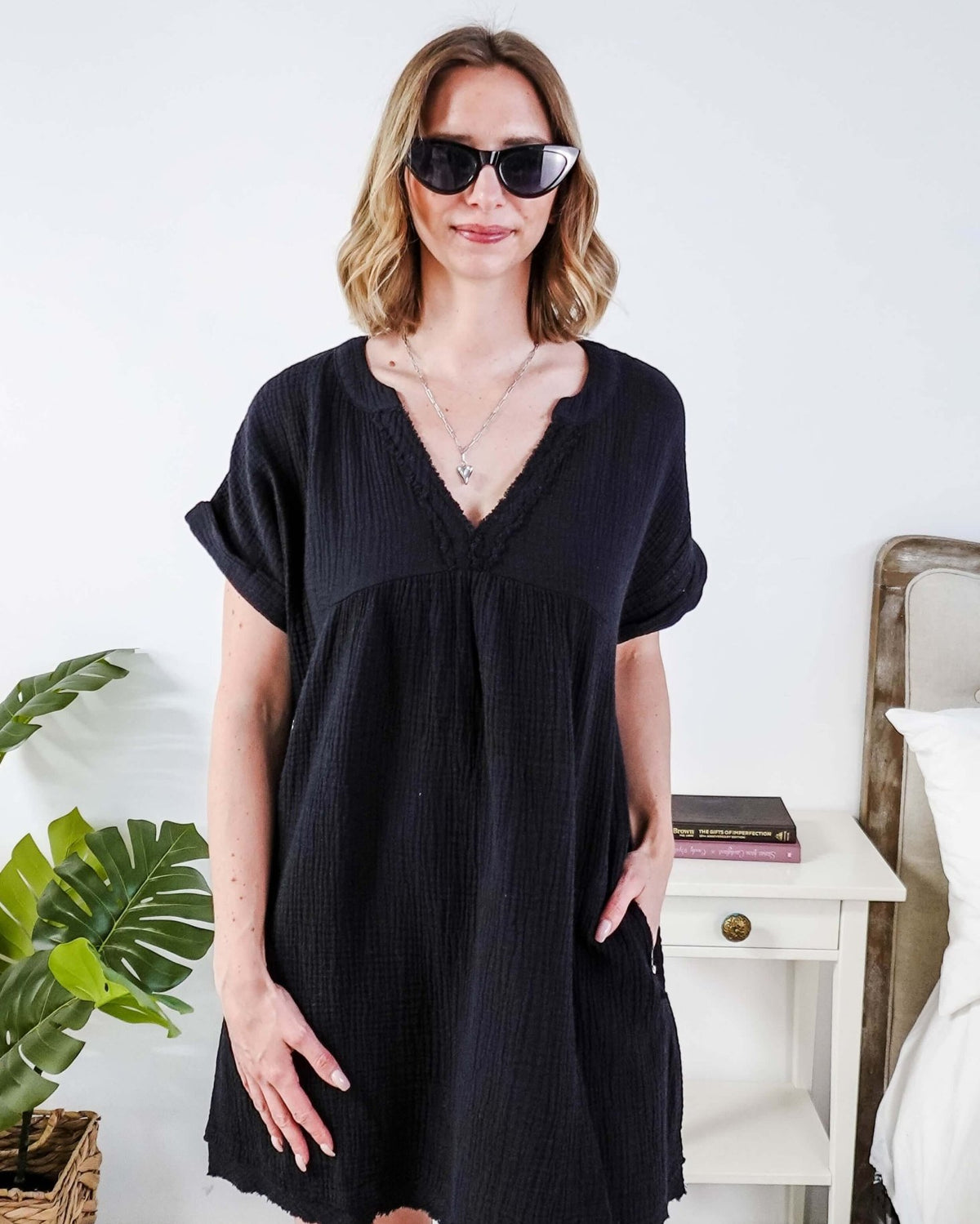 Woman wearing a black dress and sunglasses indoors with a plant and furniture in the background - Scarlett Ellie V-Neck Gauze Dress | Lightweight Summer Dress | Cloud Nine Pajamas