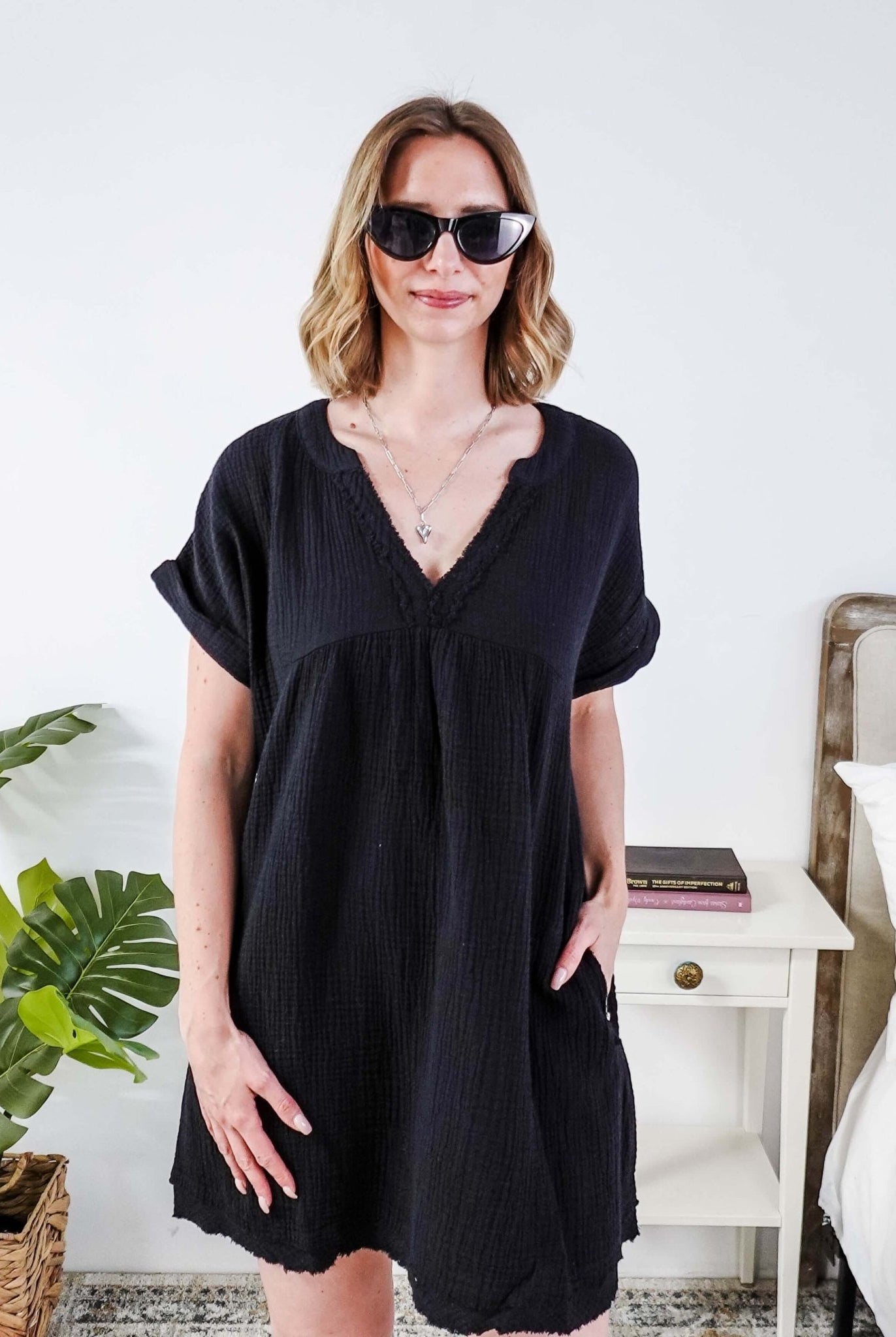 Woman wearing a black dress and sunglasses indoors with a plant and furniture in the background - Scarlett Ellie V-Neck Gauze Dress | Lightweight Summer Dress | Cloud Nine Pajamas