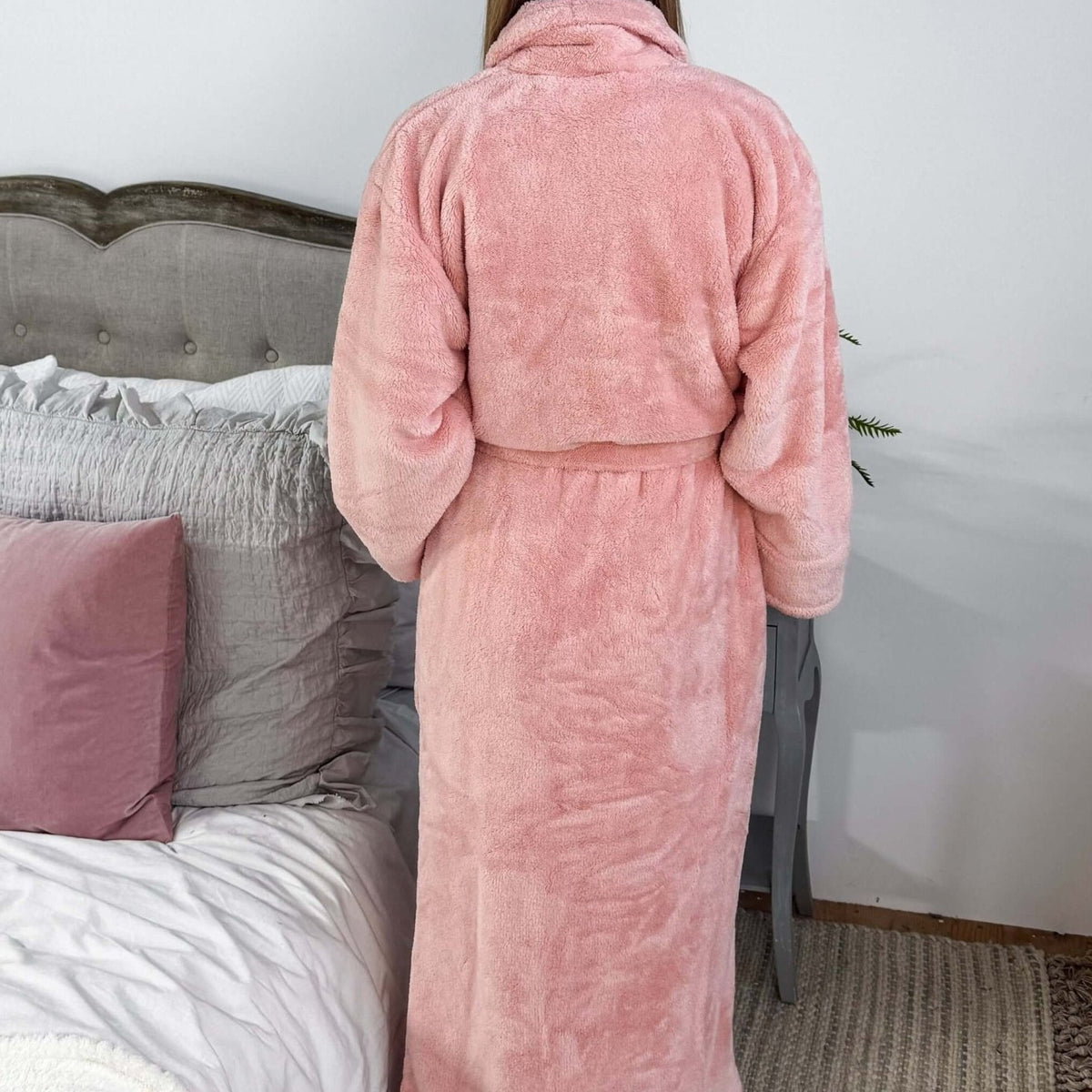 WARM BUDDY - Cozy Ultra Plush Spa Robe in Pink, Shown on a women in a bedroom setting, showing the back of the robe and the length.