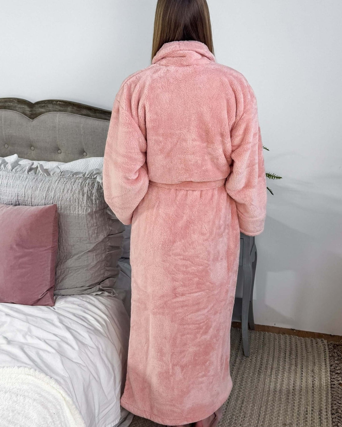 WARM BUDDY - Cozy Ultra Plush Spa Robe in Pink, Shown on a women in a bedroom setting, showing the back of the robe and the length.