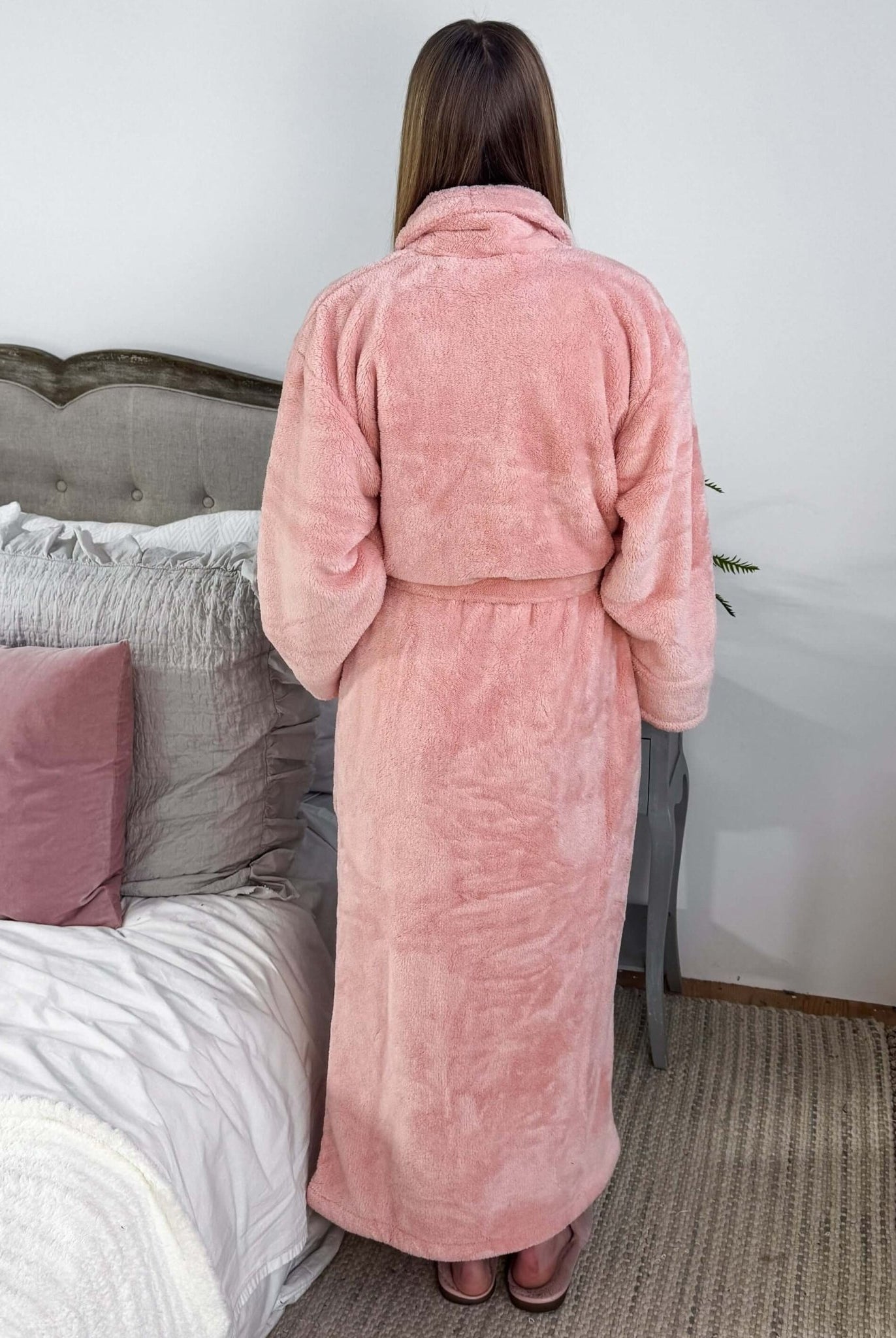 WARM BUDDY - Cozy Ultra Plush Spa Robe in Pink, Shown on a women in a bedroom setting, showing the back of the robe and the length.