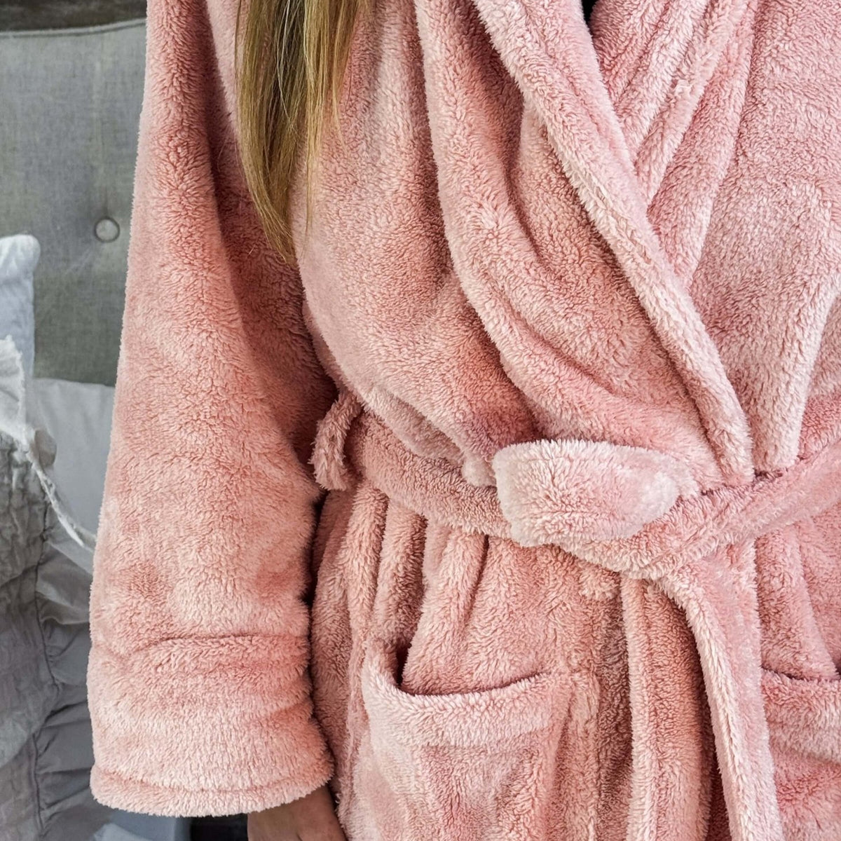 WARM BUDDY - Cozy Ultra Plush Spa Robe in Pink, Shown on a women in a bedroom setting, showing texture of the robe's plush fabric and tie waist, pocket details
