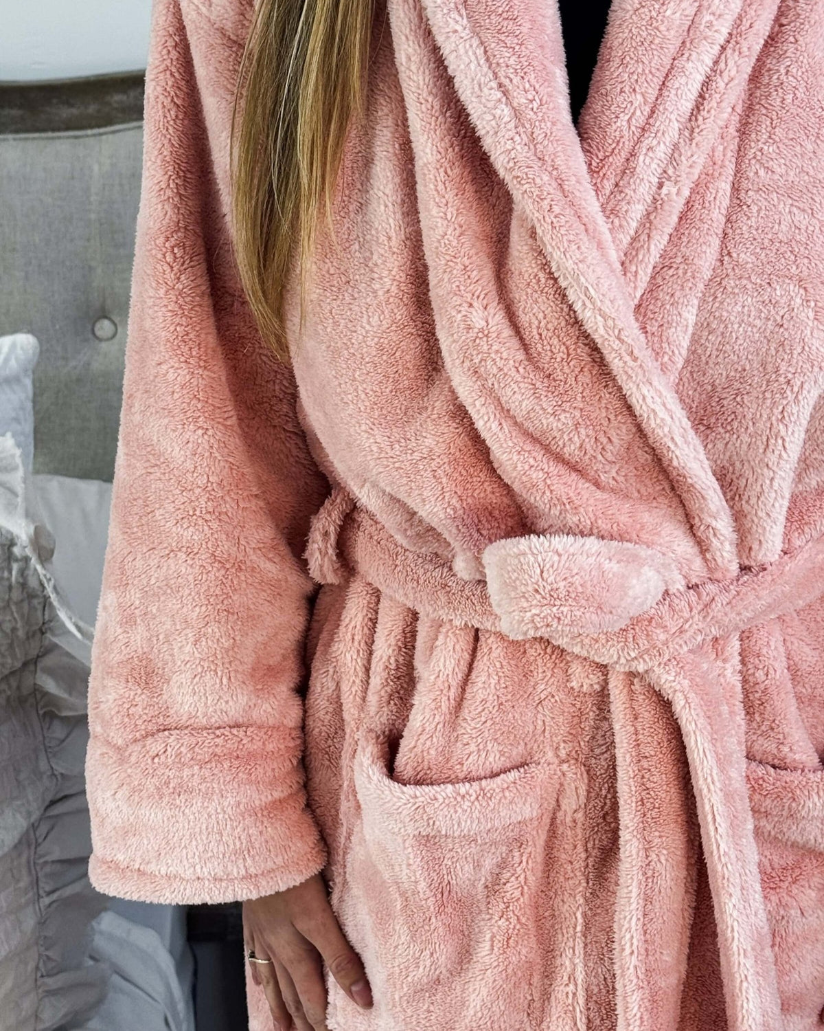 WARM BUDDY - Cozy Ultra Plush Spa Robe in Pink, Shown on a women in a bedroom setting, showing texture of the robe's plush fabric and tie waist, pocket details