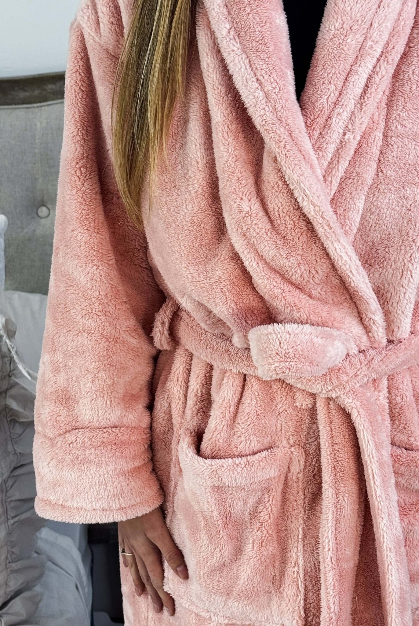 WARM BUDDY - Cozy Ultra Plush Spa Robe in Pink, Shown on a women in a bedroom setting, showing texture of the robe's plush fabric and tie waist, pocket details