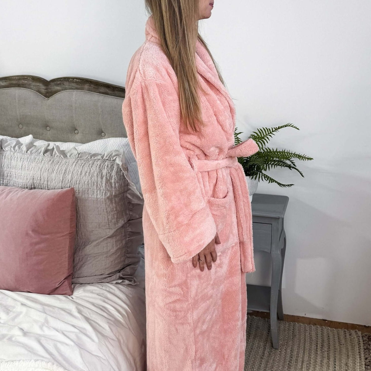 WARM BUDDY - Cozy Ultra Plush Spa Robe in Pink, Shown on a women in a bedroom setting, showing the side profile and length on 5'7" model.