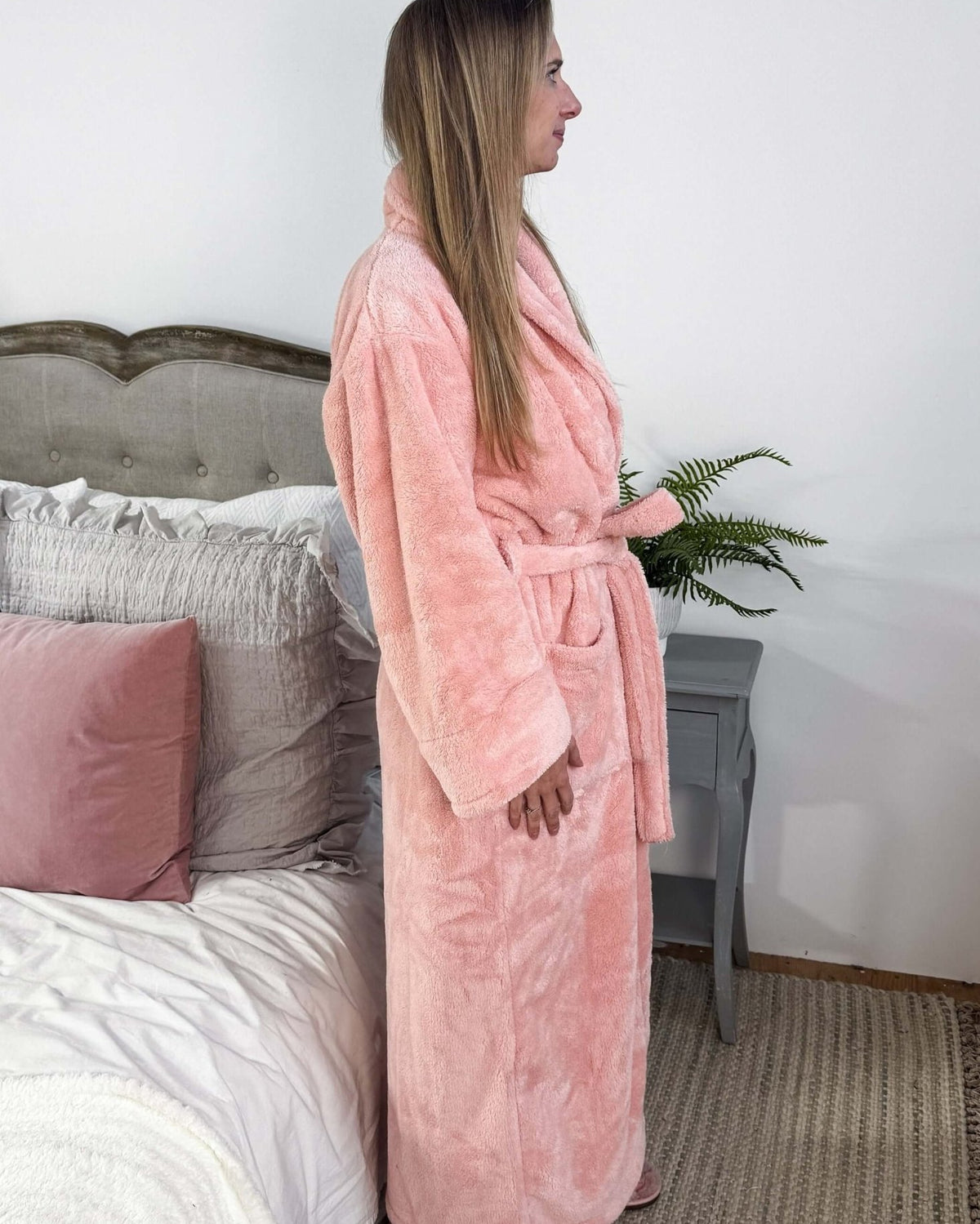 WARM BUDDY - Cozy Ultra Plush Spa Robe in Pink, Shown on a women in a bedroom setting, showing the side profile and length on 5'7" model.