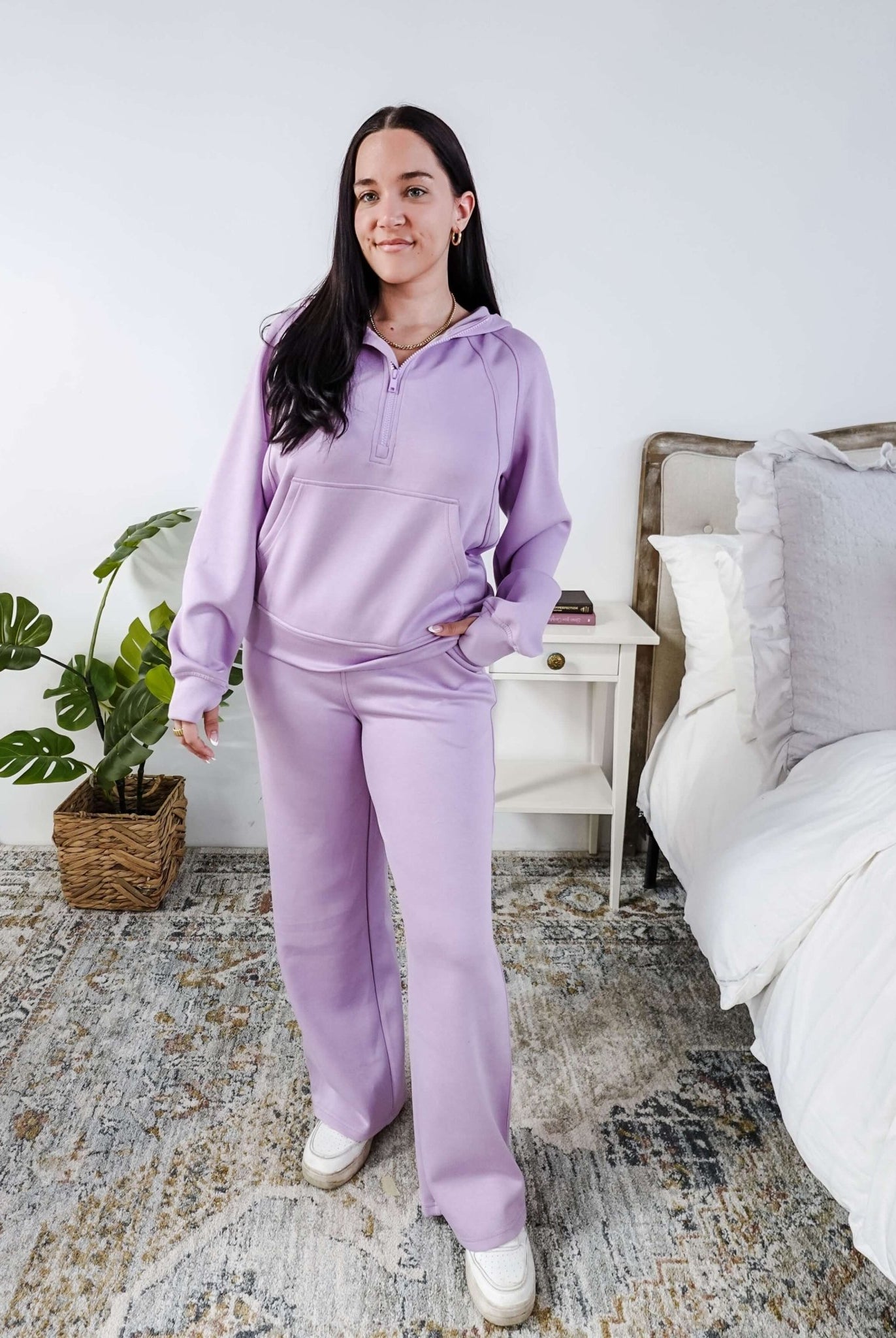 Person wearing a purple loungewear set in a bedroom.