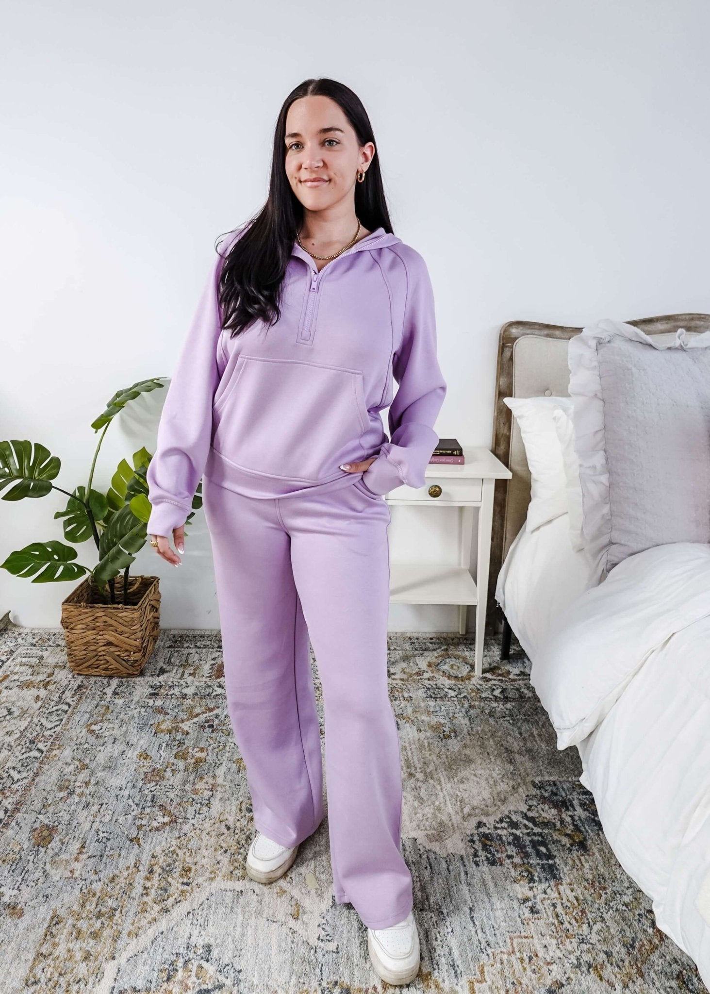 Person wearing a purple loungewear set in a bedroom.