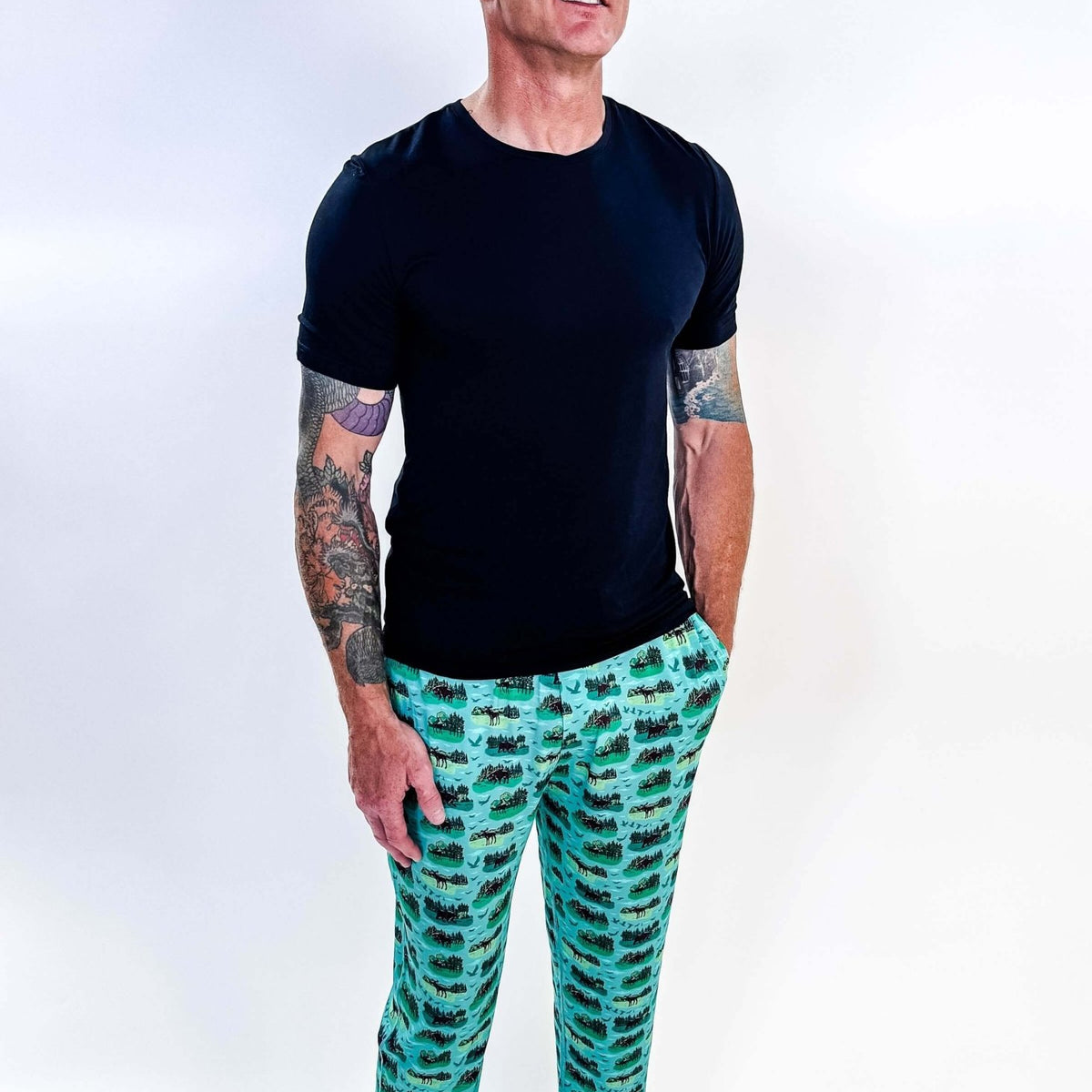 Model wearing Wildlife Aqua Unisex Bamboo Joggers with a black t-shirt, showcasing vibrant aquatic print.