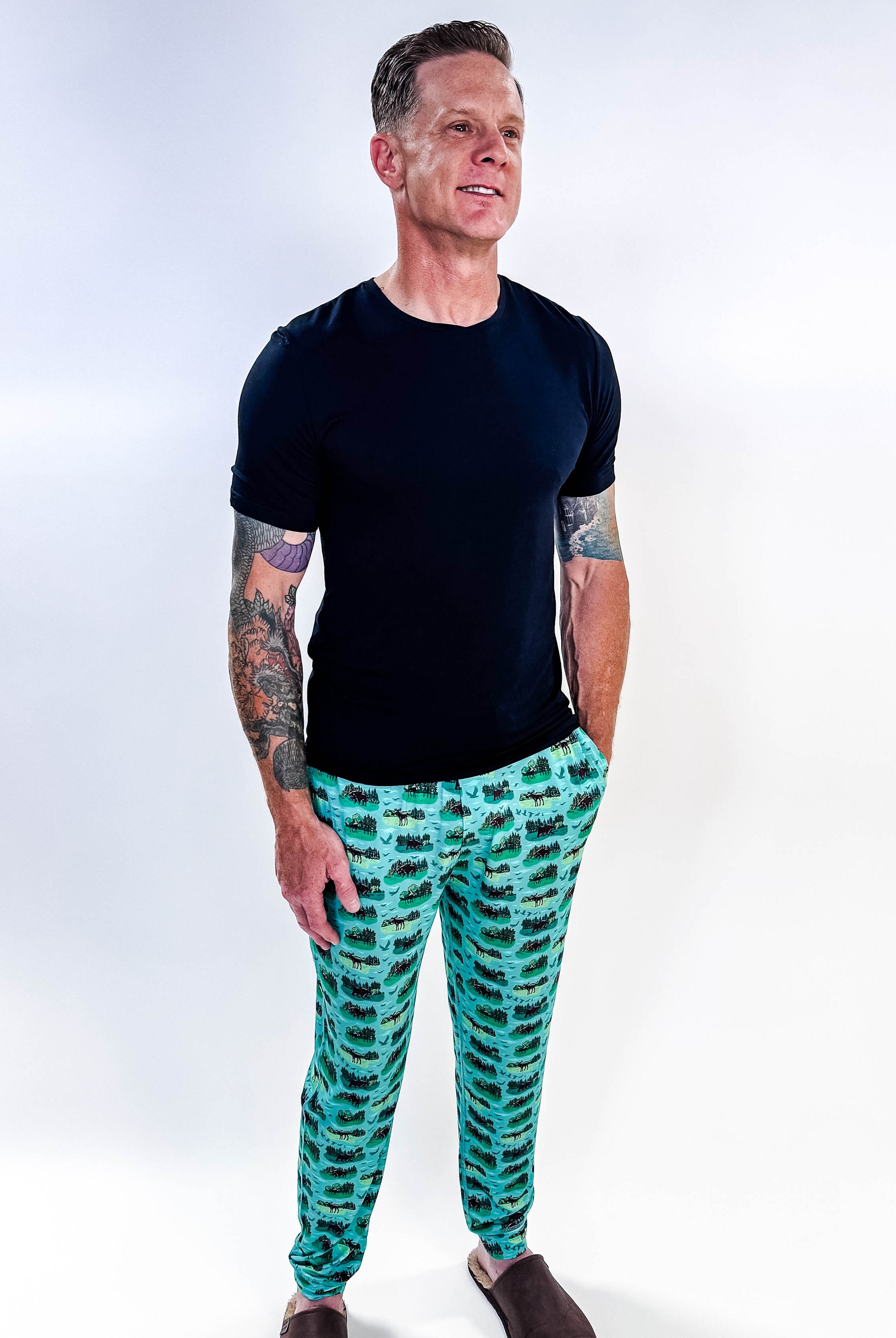 Model wearing Wildlife Aqua Unisex Bamboo Joggers with a black t-shirt, showcasing vibrant aquatic print.