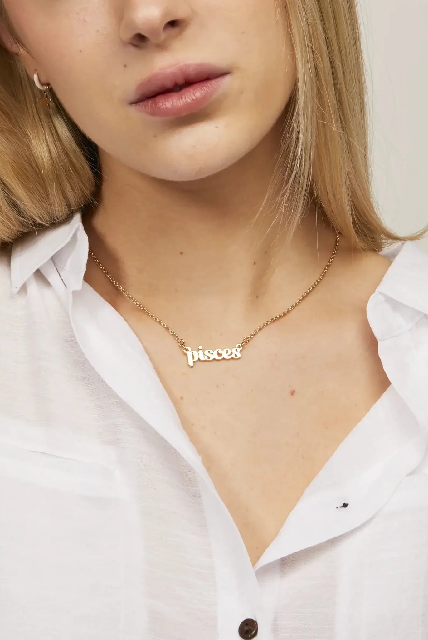 Zodiac Script Necklace in 14K Plated Gold featuring the Pisces astrological sign on a bright yellow display card.