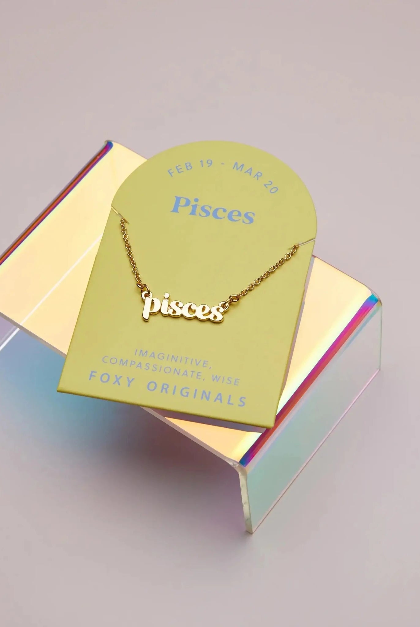 Zodiac Script Necklace in 14K Plated Gold featuring the Pisces astrological sign on a bright yellow display card.