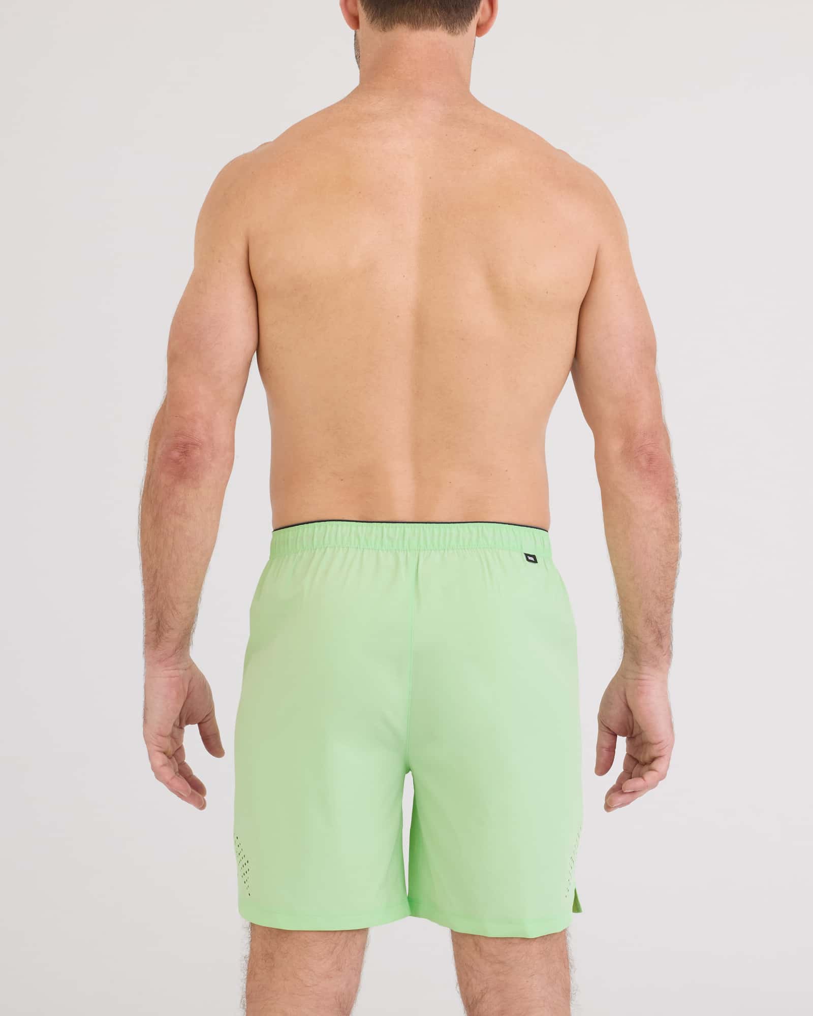 Back view of a man wearing Power Moves 2N1 Short 7 in bright green, showcasing the lightweight and stylish design.