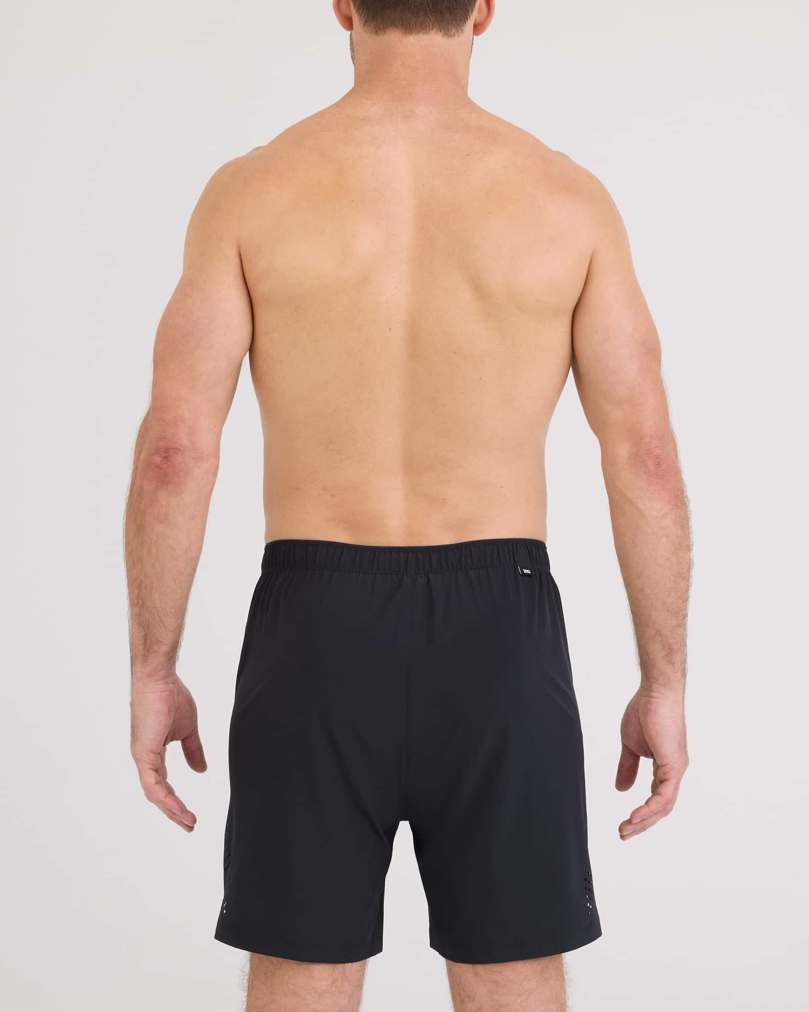 Back view of a man wearing Power Moves 2N1 Short 7 from SAXX, showcasing the black sporty design.