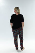 Woman wearing Arcade After Dark Unisex Bamboo Jogger from Bob's Sleepwear Co., showcasing a colorful design.