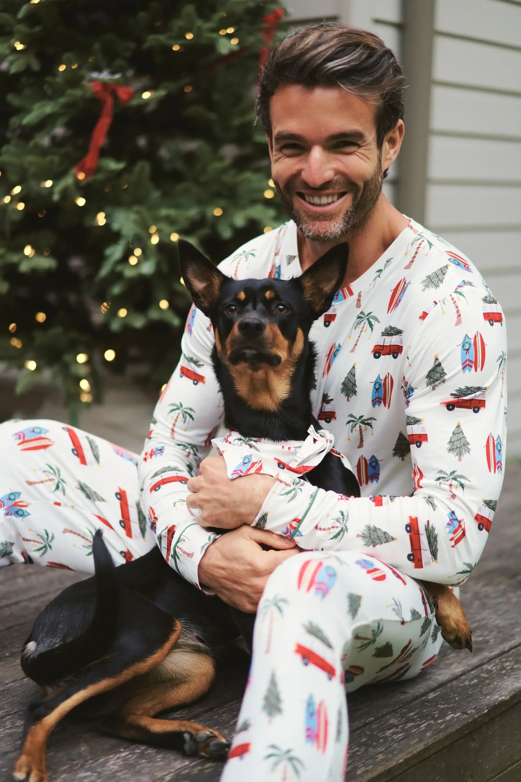 Holiday Print Bamboo Pet Bandana worn by a dog with owner in festive pajamas, celebrating the holiday season.